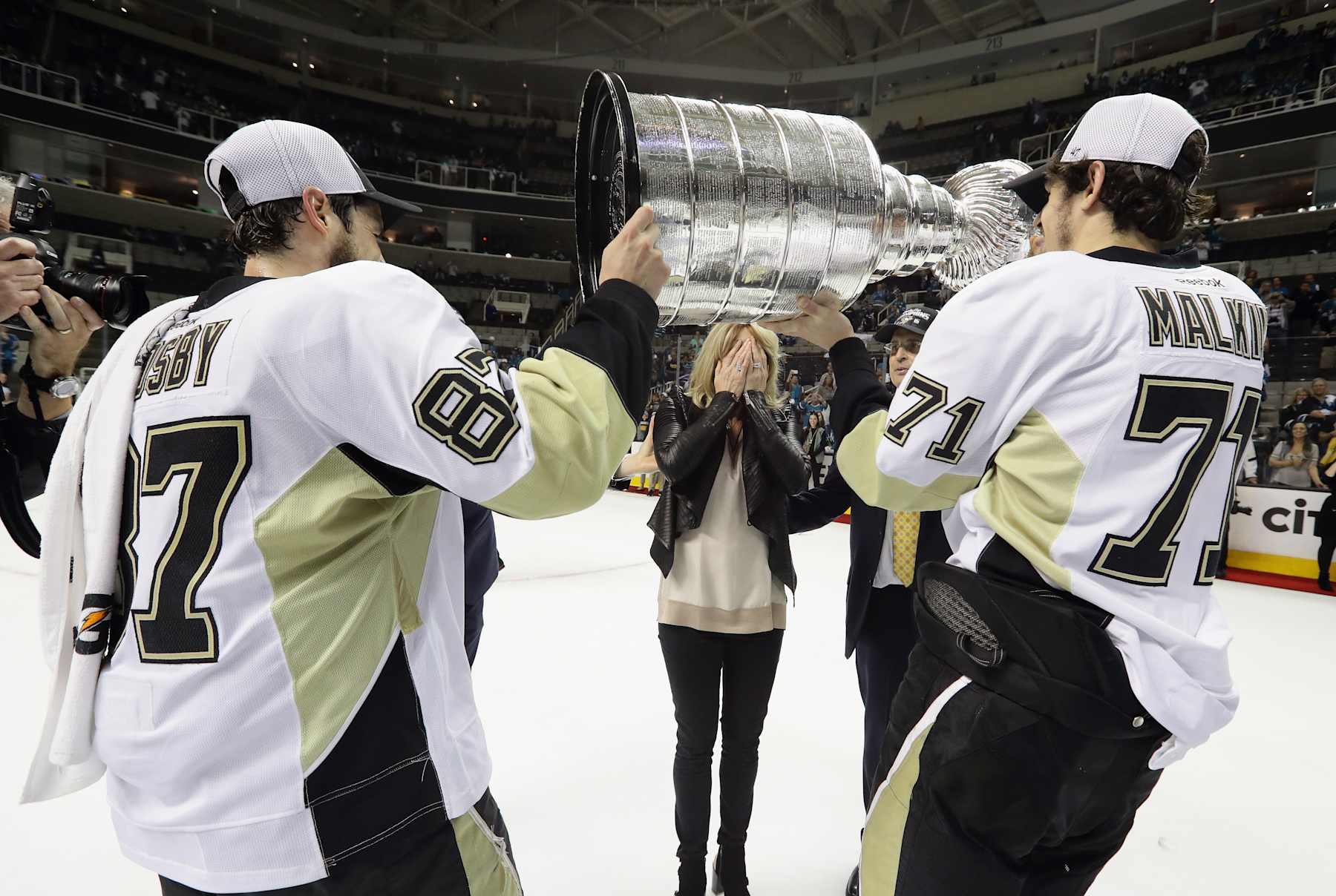 SAN JOSE, CA - JUNE 12:  Sidney Crosby #87 and Evgeni Malkin #71 of the Pittsburgh Penguins carry the Stanley Cup to Nathalie Lemieux (wife of Mario) after defeating the San Jose Sharks  in Game Six of the 2016 NHL Stanley Cup Final at SAP Center on June 12, 2016 in San Jose, California.  (Photo by Bruce Bennett/Getty Images)