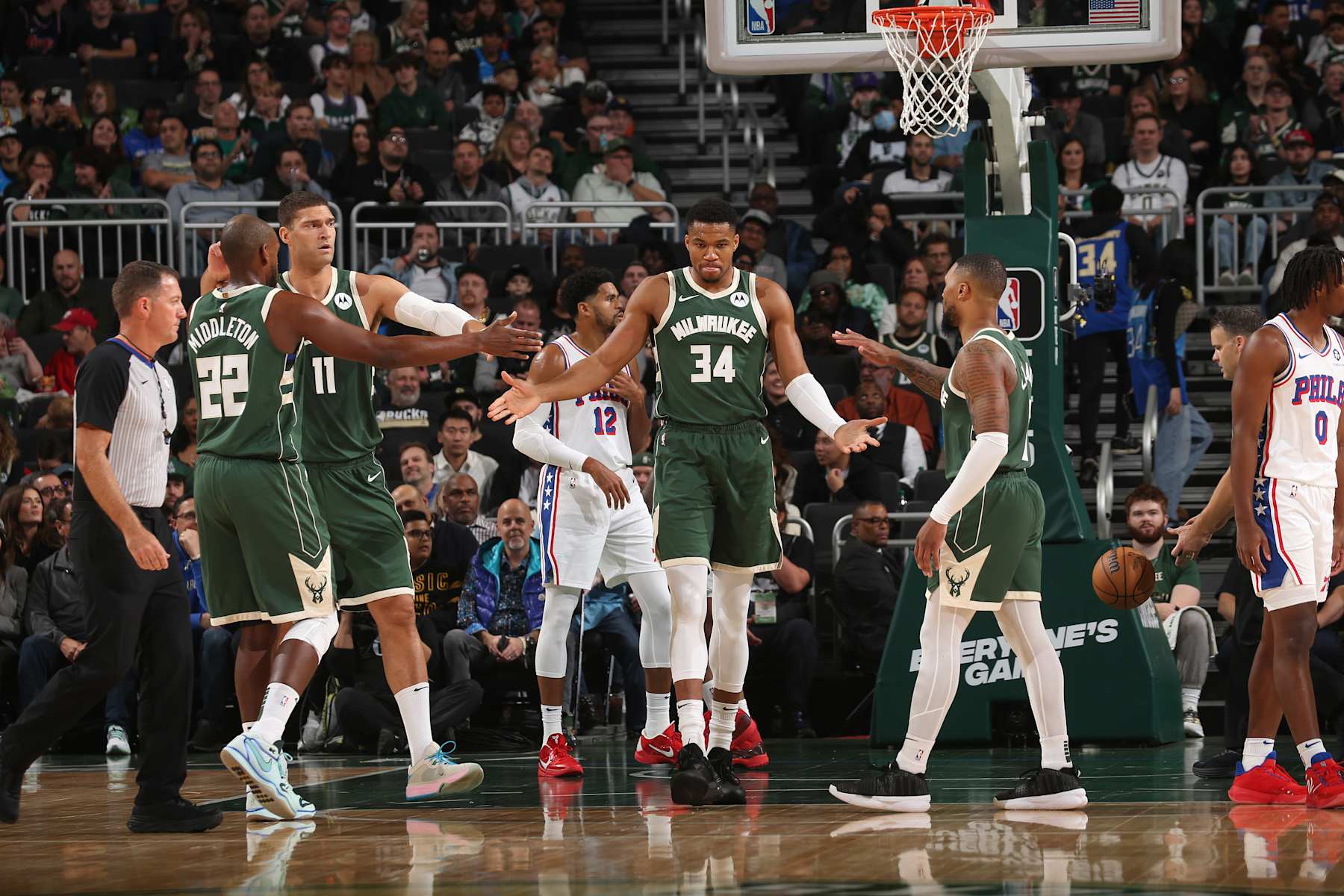 MILWAUKEE, WI - OCTOBER 26: Giannis Antetokounmpo #34, Khris Middleton #22, Brook Lopez #11 and Damian Lillard #0 of the Milwaukee Bucks high five during the game against the Philadelphia 76ers on October 26, 2023 at the Fiserv Forum Center in Milwaukee, Wisconsin. NOTE TO USER: User expressly acknowledges and agrees that, by downloading and or using this Photograph, user is consenting to the terms and conditions of the Getty Images License Agreement. Mandatory Copyright Notice: Copyright 2023 NBAE (Photo by Gary Dineen/NBAE via Getty Images).