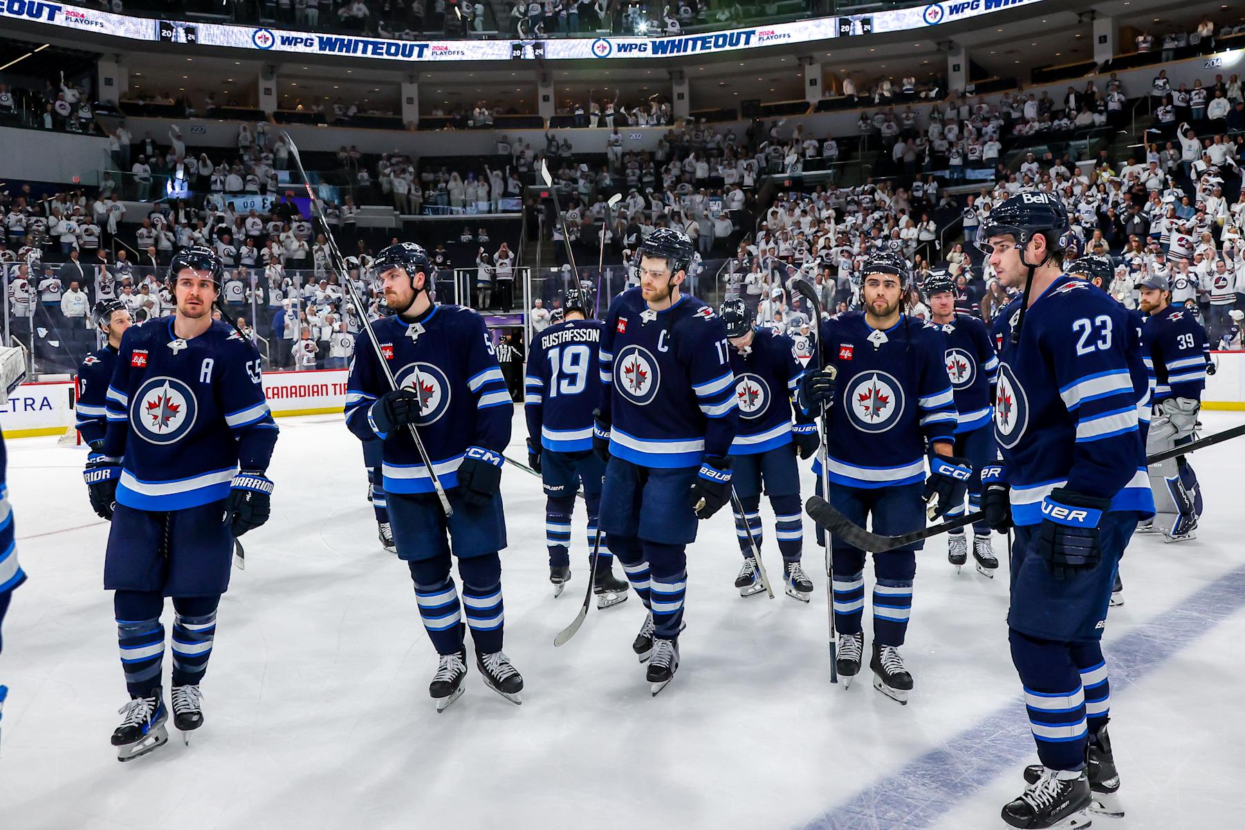 WINNIPEG, CANADA - APRIL 30: Mark Scheifele #55, Dylan Samberg #54, Adam Lowry #17, Alex Iafallo #9, and Sean Monahan #23 of the Winnipeg Jets look on in disappointment following a 6-3 loss to the Colorado Avalanche in Game Five of the First Round of the 2024 Stanley Cup Playoffs at Canada Life Centre on April 30, 2024 in Winnipeg, Manitoba, Canada. (Photo by Jonathan Kozub/NHLI via Getty Images)