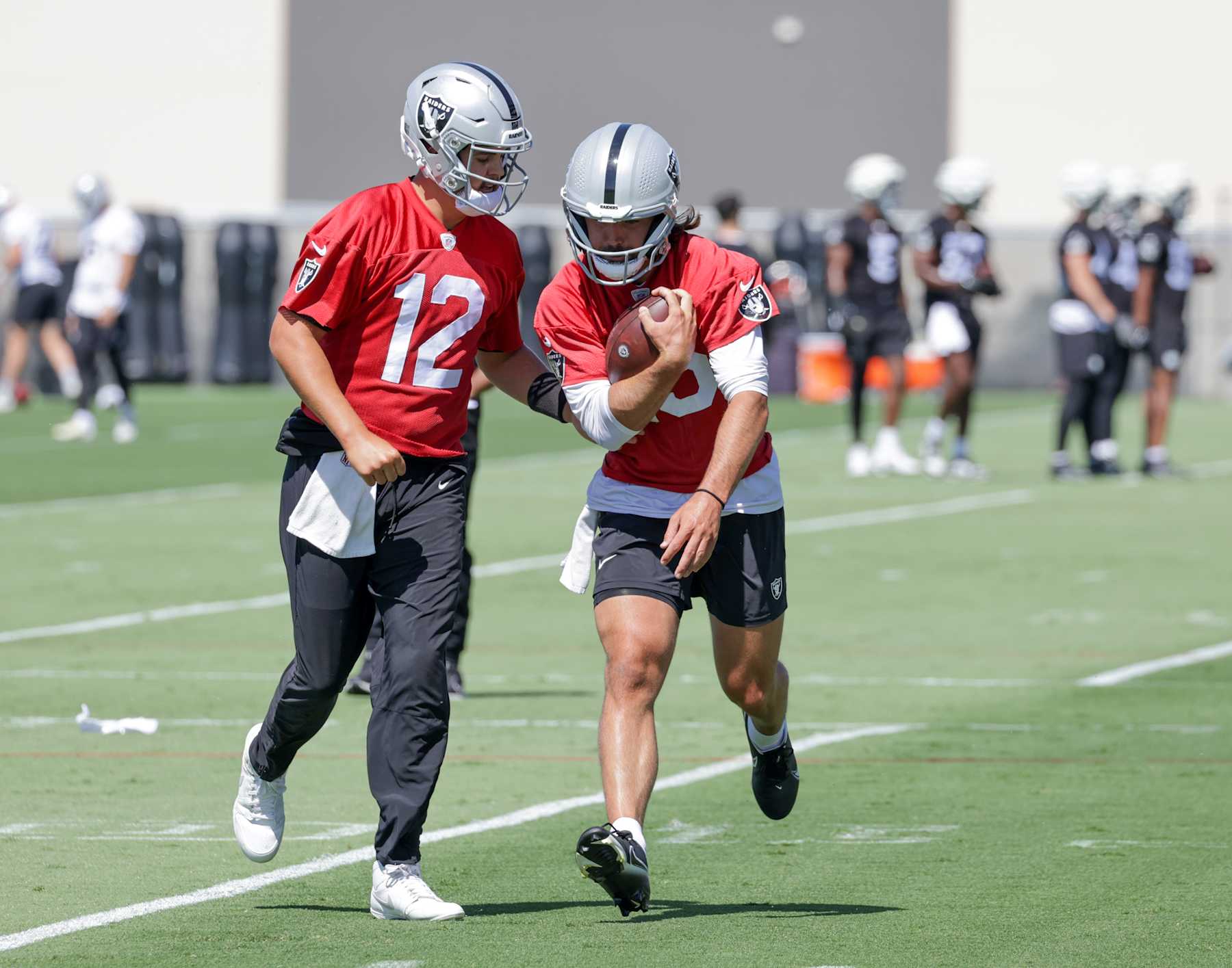 HENDERSON, NEVADA - MAY 29: Quarterbacks Aidan O'Connell #12 and Gardner Minshew #15 of the Las Vegas Raiders run through a drill during an OTA offseason workout at the Las Vegas Raiders Headquarters/Intermountain Healthcare Performance Center on May 29, 2024 in Henderson, Nevada. (Photo by Ethan Miller/Getty Images)
