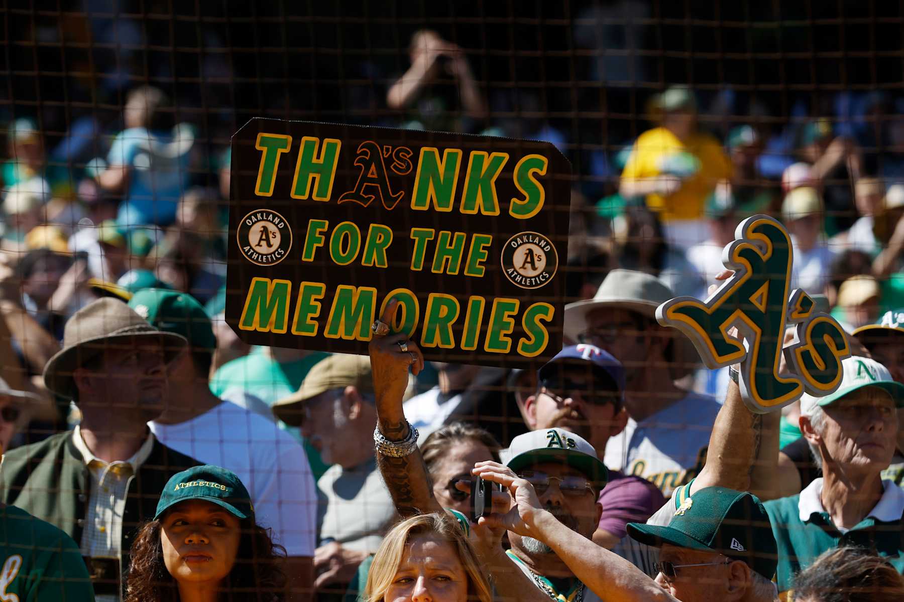 OAKLAND, CA - SEPTEMBER 26: Fans hold up signs prior to the game between the Texas Rangers and the Oakland Athletics at RingCentral Coliseum on Thursday, September 26, 2024 in Oakland, California. (Photo by Lachlan Cunningham/MLB Photos via Getty Images)