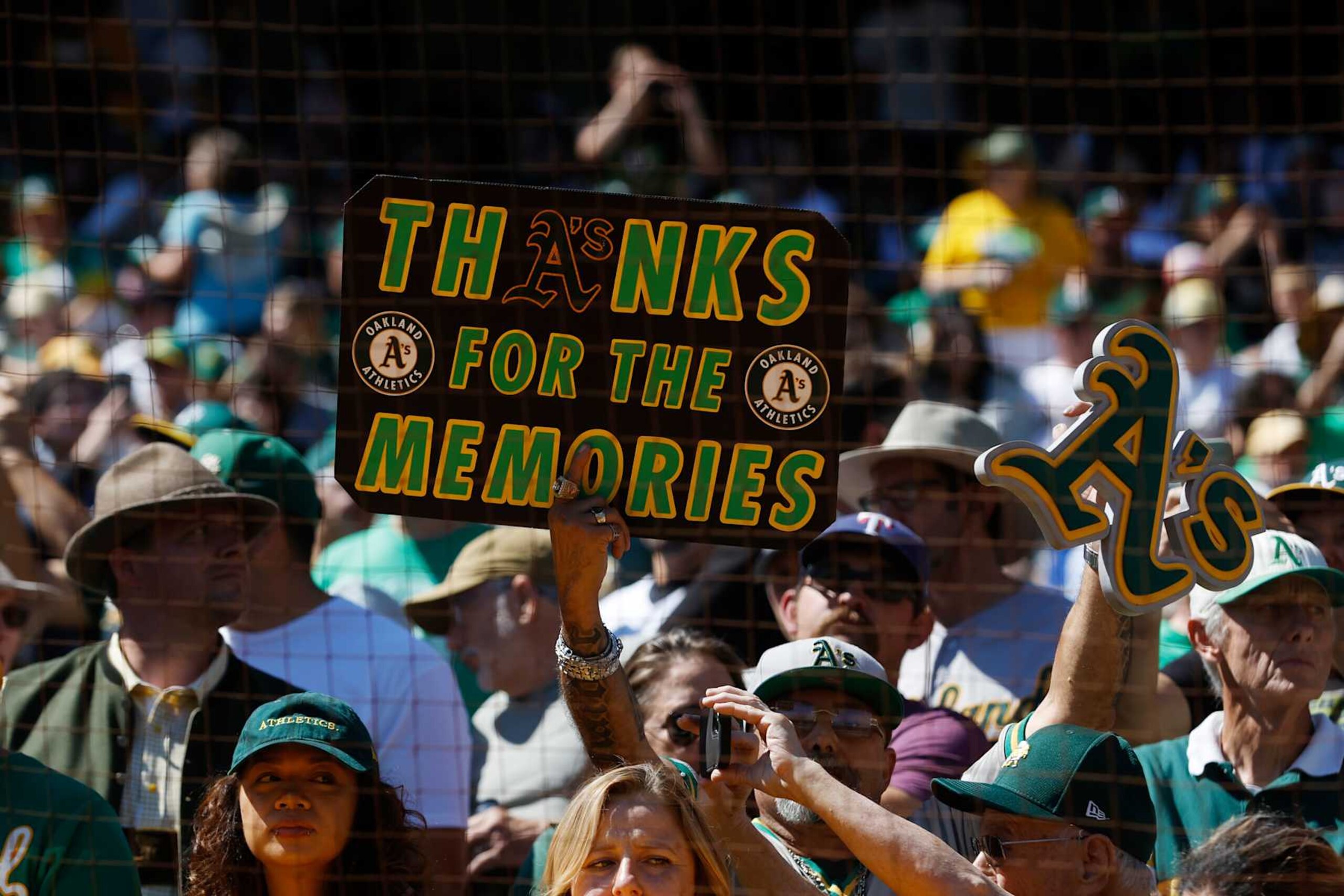 OAKLAND, CA - SEPTEMBER 26: Fans hold up signs prior to the game between the Texas Rangers and the Oakland Athletics at RingCentral Coliseum on Thursday, September 26, 2024 in Oakland, California. (Photo by Lachlan Cunningham/MLB Photos via Getty Images)