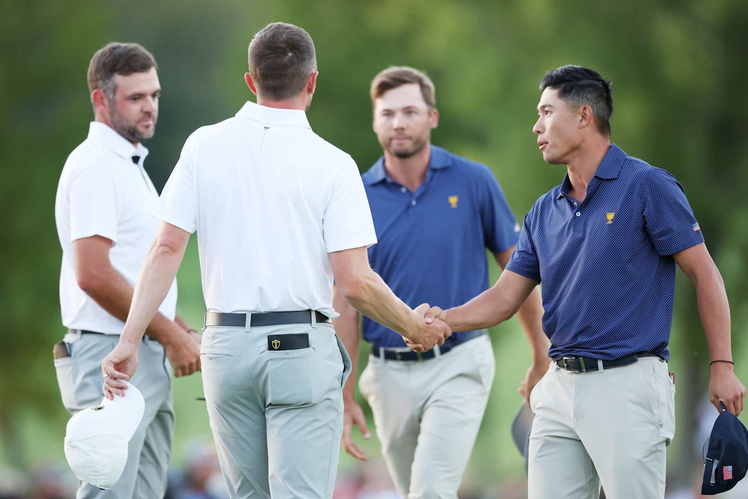 MONTREAL, QUEBEC - SEPTEMBER 28: Collin Morikawa and Sam Burns of the U.S. Team shake hands with Mackenzie Hughes and Corey Conners of Canada and the International Team after their 1 UP victory during Saturday Afternoon Foursomes on day three of the  2024 Presidents Cup at The Royal Montreal Golf Club on September 28, 2024 in Montreal, Quebec, Canada. (Photo by Harry How/Getty Images)