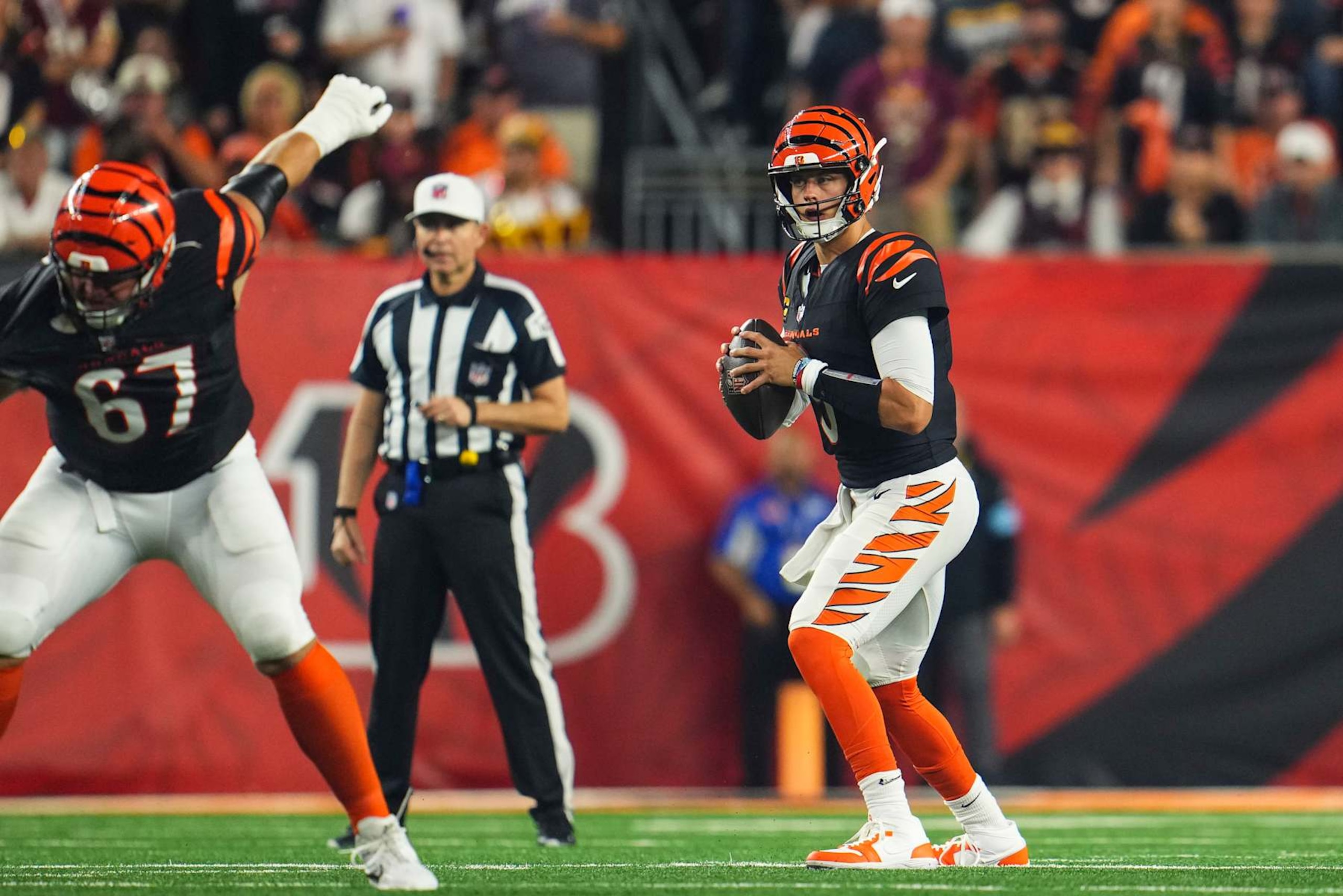 CINCINNATI, OH - SEPTEMBER 23: Joe Burrow #9 of the Cincinnati Bengals drops back to pass during an NFL football game against the Washington Commanders at Paycor Stadium on September 23, 2024 in Cincinnati, Ohio. (Photo by Cooper Neill/Getty Images) CINCINNATI, OH - SEPTEMBER 23: Joe Burrow #9 of the Cincinnati Bengals drops back to pass during an NFL football game against the Washington Commanders at Paycor Stadium on September 23, 2024 in Cincinnati, Ohio. (Photo by Cooper Neill/Getty Images)