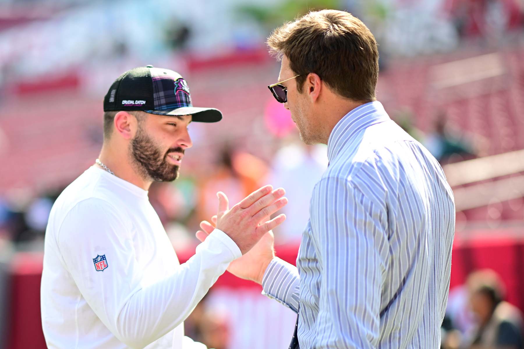 TAMPA, FLORIDA - SEPTEMBER 29: Baker Mayfield #6 of the Tampa Bay Buccaneers and former NFL player Tom Brady embrace prior to a game against the Philadelphia Eagles at Raymond James Stadium on September 29, 2024 in Tampa, Florida. (Photo by Julio Aguilar/Getty Images)