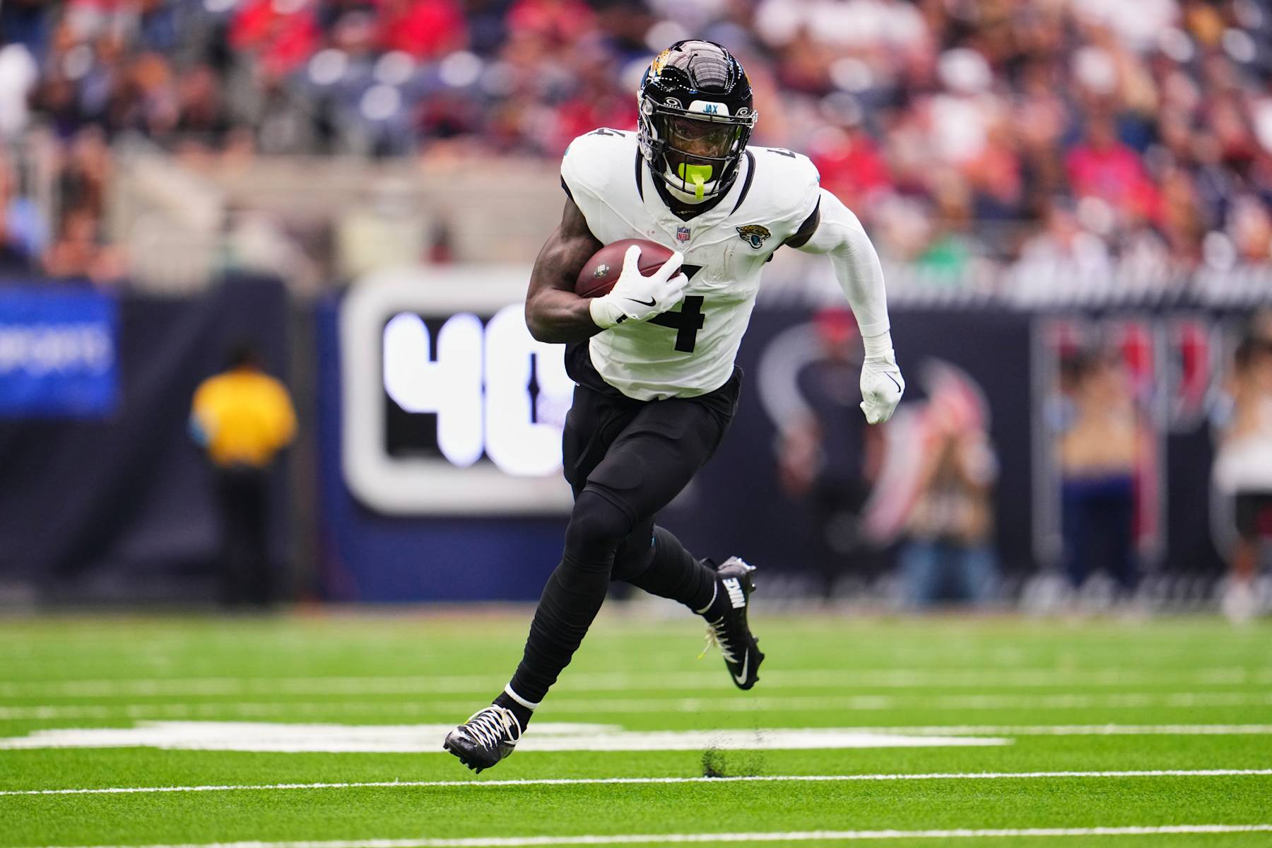 HOUSTON, TX - SEPTEMBER 29: Tank Bigsby #4 of the Jacksonville Jaguars runs with the ball agains the Houston Texans during the first half of a football game at NRG Stadium on September 29, 2024 in Houston, Texas. (Photo by Cooper Neill/Getty Images)