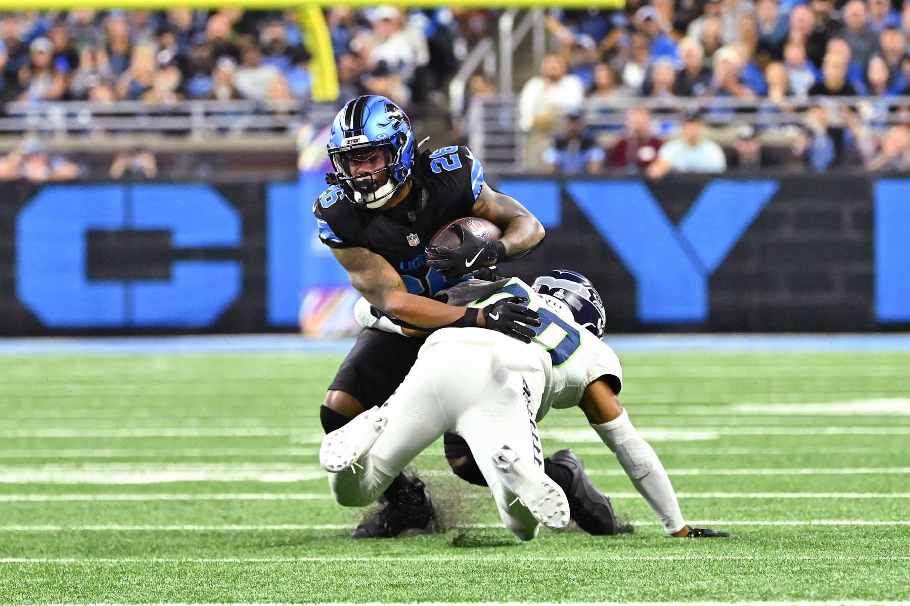 DETROIT, MI - SEPTEMBER 30: Detroit Lions running back Jahmyr Gibbs (26) runs wide for a big gain and is tackled by Seattle Seahawks safety Julian Love (20) during the Detroit Lions versus the Seattle Seahawks game on Monday September 30, 2024 at Ford Field in Detroit, MI. (Photo by Steven King/Icon Sportswire via Getty Images)