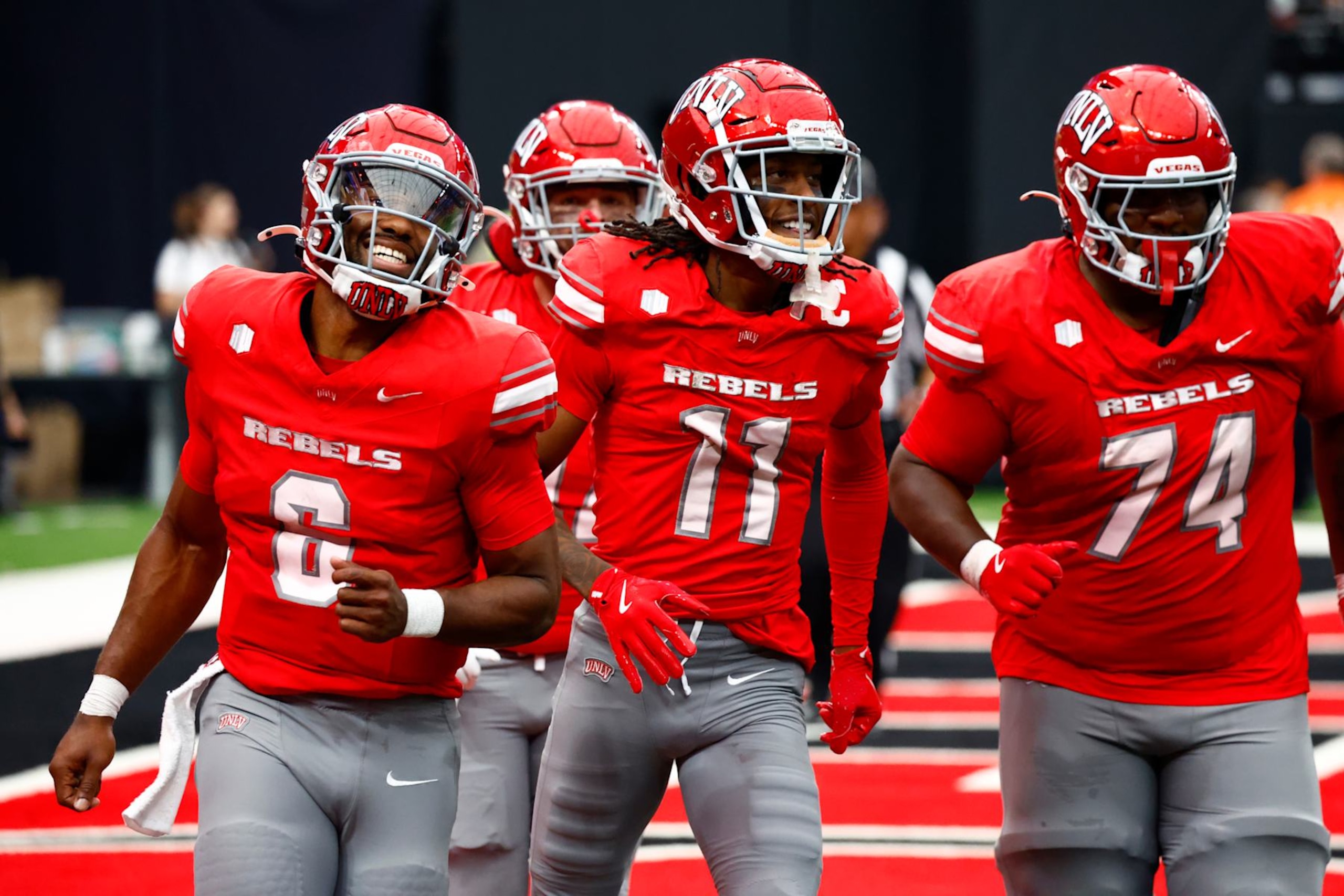 LAS VEGAS, NV - SEPTEMBER 28: Quarterback Hajj-Malik Williams (6), wide receiver Ricky White III (11), and offensive lineman Jalen St. John (74) of the UNLV Rebels celebrate after a touchdown pass by Williams to White during a Mountain West Conference game between the Fresno State Bulldogs and the UNLV Rebels on September 28, 2024 at Allegiant Stadium in Las Vegas, Nevada. (Photo by Jeff Speer/Icon Sportswire via Getty Images)