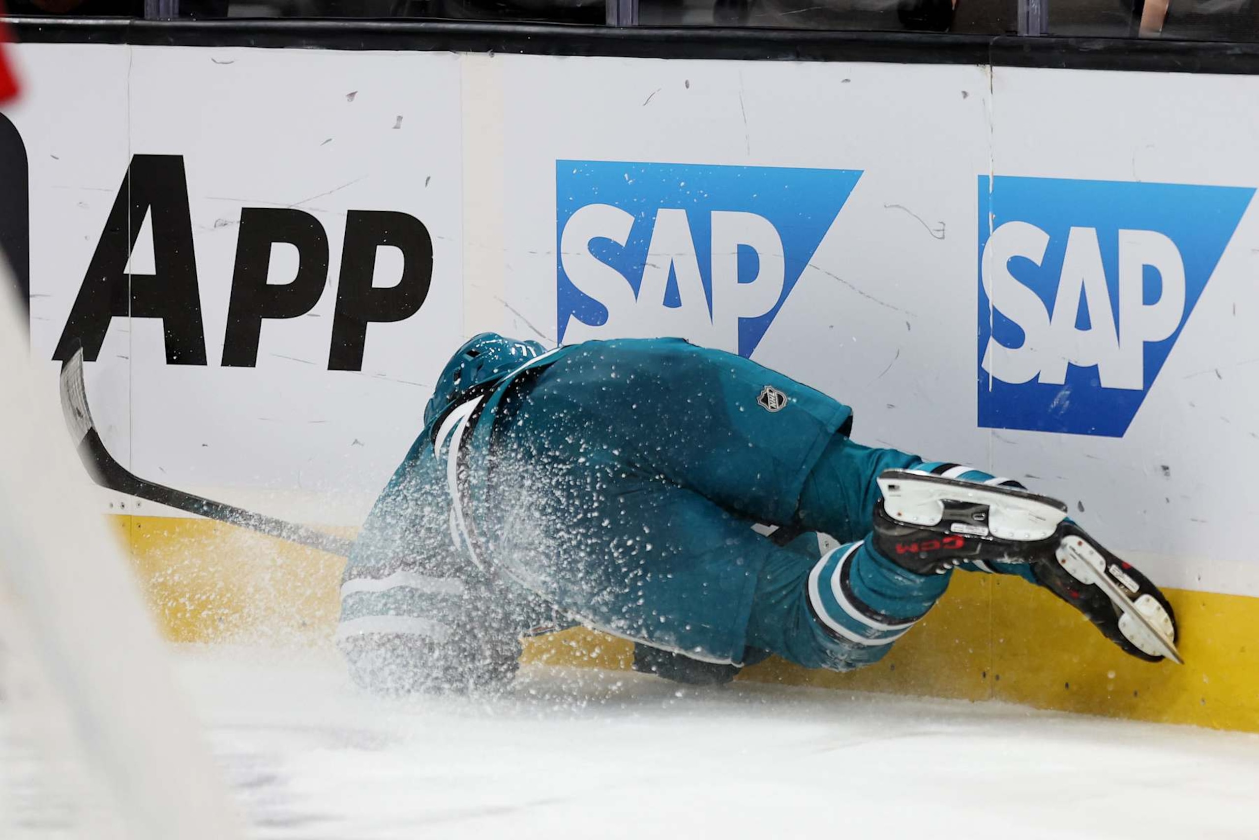 SAN JOSE, CALIFORNIA - OCTOBER 01: Macklin Celebrini #71 of the San Jose Sharks slides into the boards in the second period of their preseason game against the Utah Hockey Club at SAP Center on October 01, 2024 in San Jose, California. He did not come back to play in the third period.  (Photo by Ezra Shaw/Getty Images)