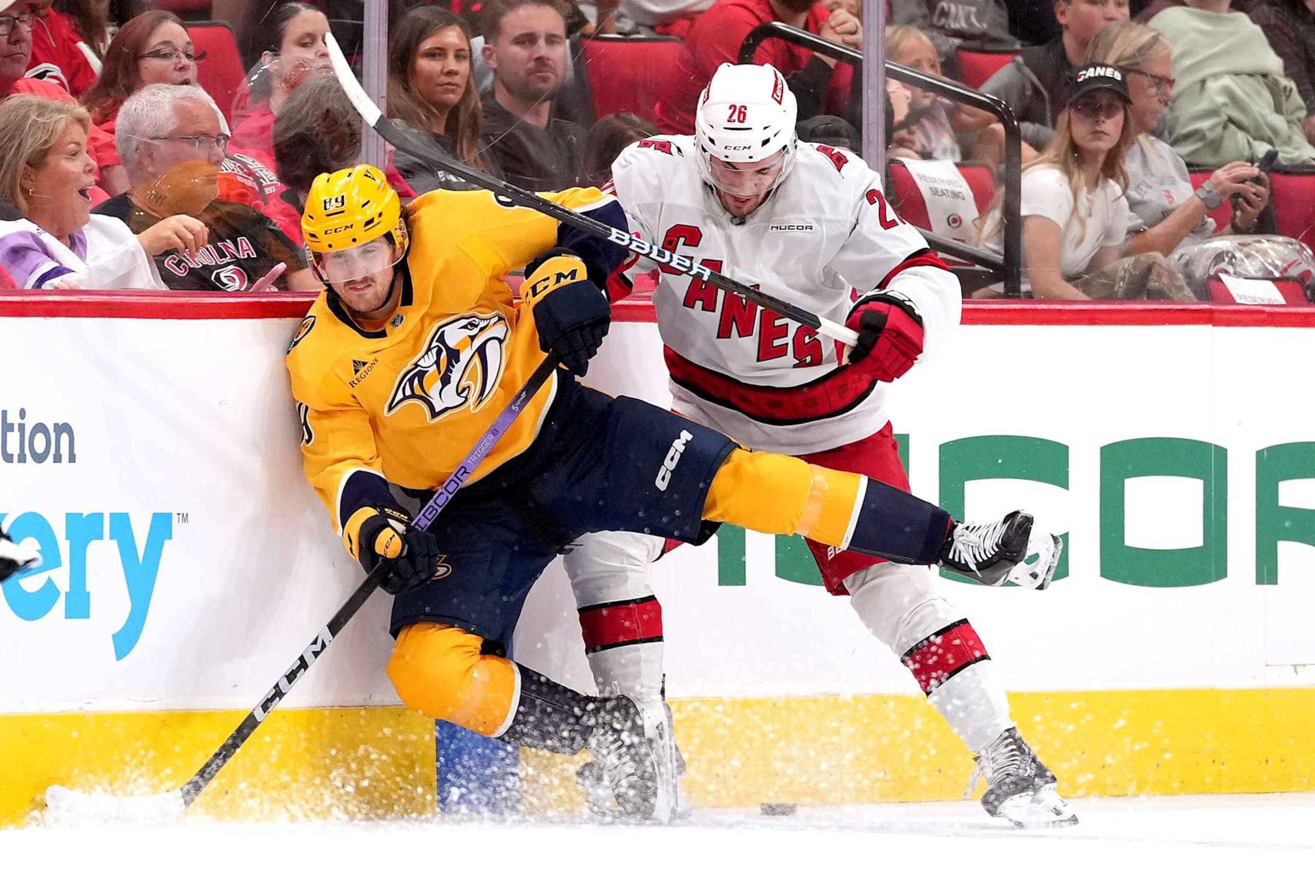 RALEIGH, NORTH CAROLINA - OCTOBER 02: Ozzy Wiesblatt #89 of the Nashville Predators battles Sean Walker #26 of the Carolina Hurricanes for the puck during a preseason game at Lenovo Center on October 02, 2024 in Raleigh, North Carolina.  (Photo by Grant Halverson/Getty Images)