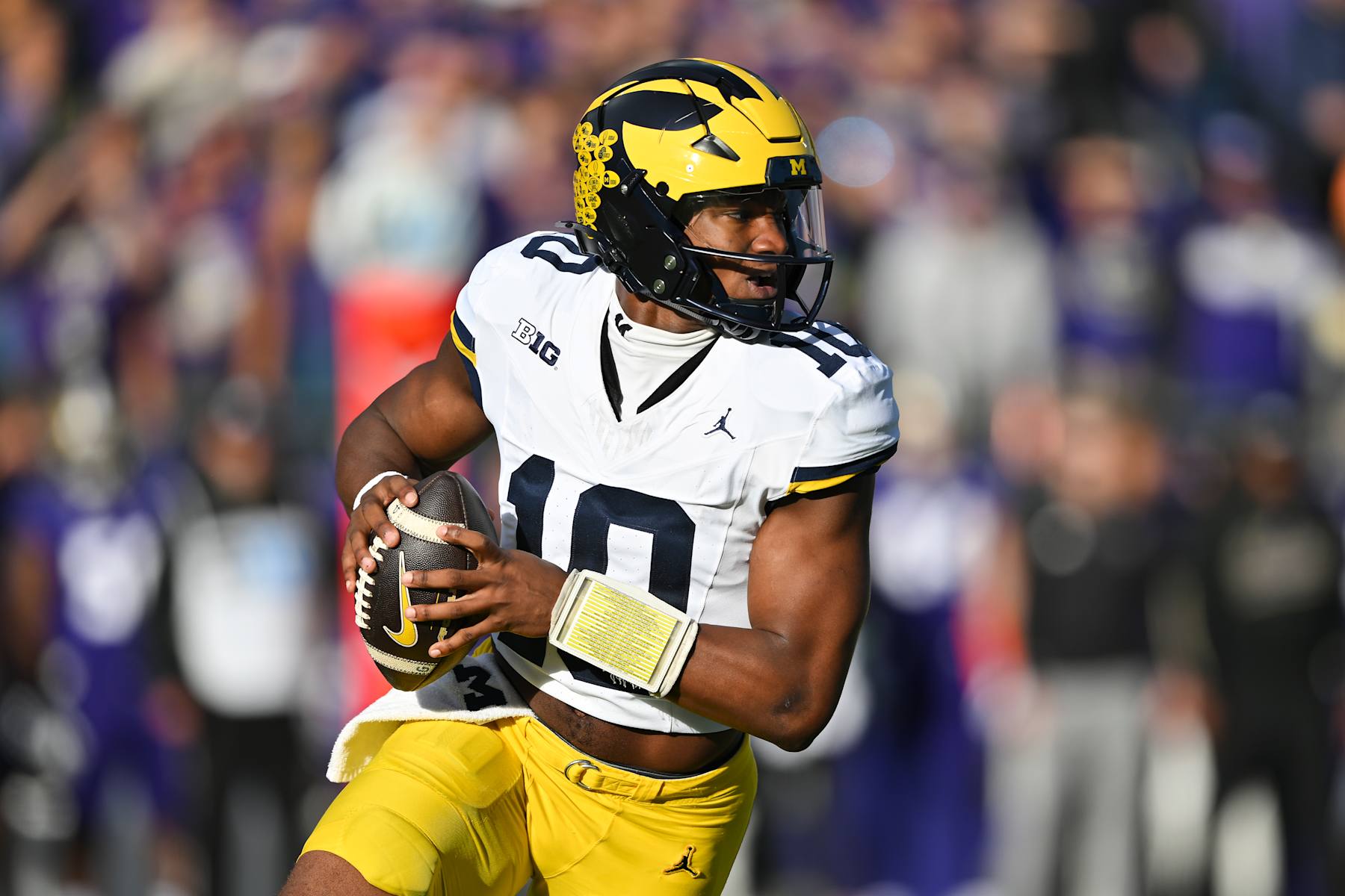 SEATTLE, WASHINGTON - OCTOBER 05: Alex Orji #10 of the Michigan Wolverines rolls out of the pocket during the first quarter of the game against the Washington Huskies at Husky Stadium on October 05, 2024 in Seattle, Washington. (Photo by Alika Jenner/Getty Images)