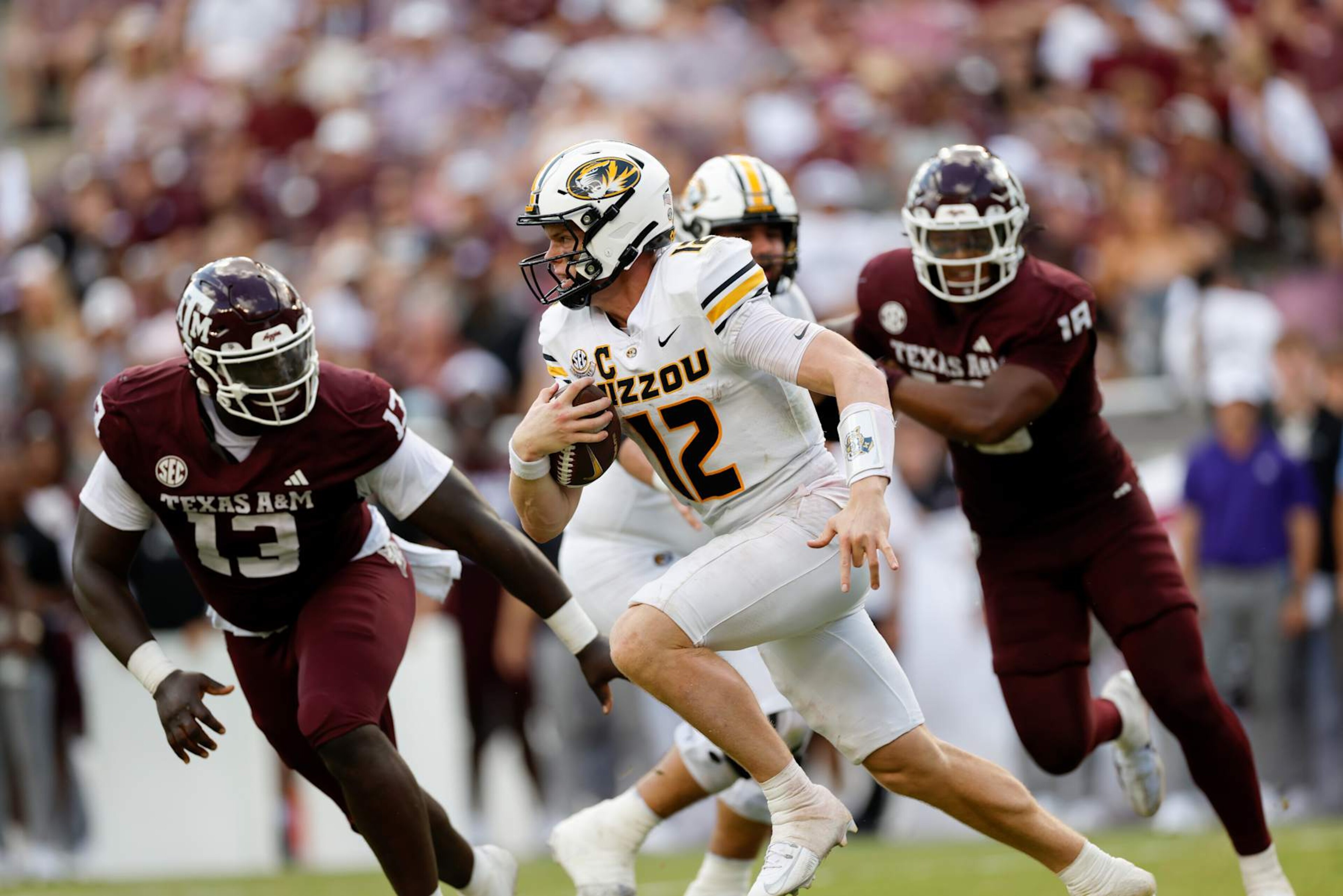 COLLEGE STATION, TEXAS - OCTOBER 05: Brady Cook #12 of the Missouri Tigers scrambles while defended by DJ Hicks #13 of the Texas A&M Aggies in the second half at Kyle Field on October 05, 2024 in College Station, Texas. (Photo by Tim Warner/Getty Images) COLLEGE STATION, TEXAS - OCTOBER 05: Brady Cook #12 of the Missouri Tigers scrambles while defended by DJ Hicks #13 of the Texas A&M Aggies in the second half at Kyle Field on October 05, 2024 in College Station, Texas. (Photo by Tim Warner/Getty Images)