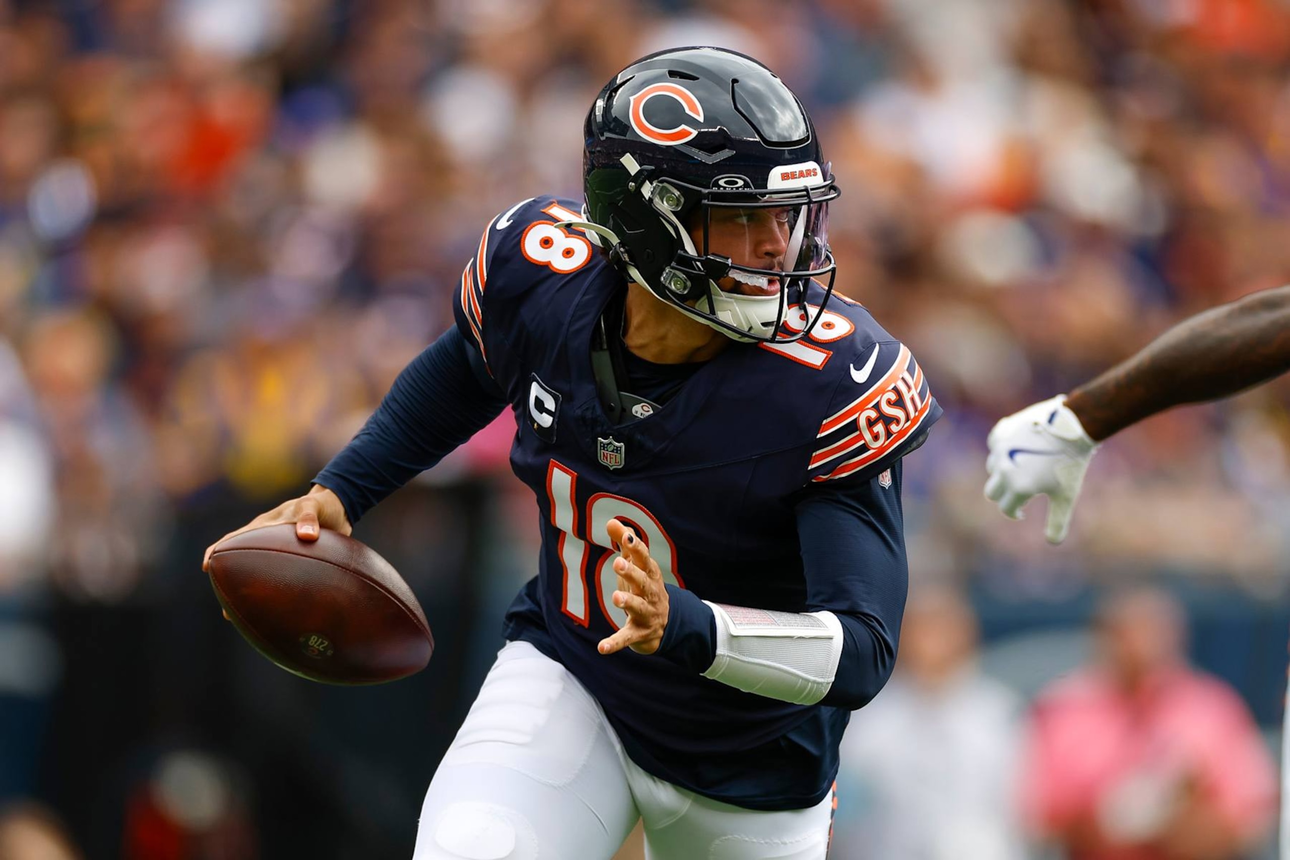 CHICAGO, ILLINOIS - SEPTEMBER 29: Caleb Williams #18 of the Chicago Bears rolls out to throw a pass under pressure during the first half against the Los Angeles Rams at Soldier Field on September 29, 2024 in Chicago, Illinois. (Photo by Brandon Sloter/Getty Images)