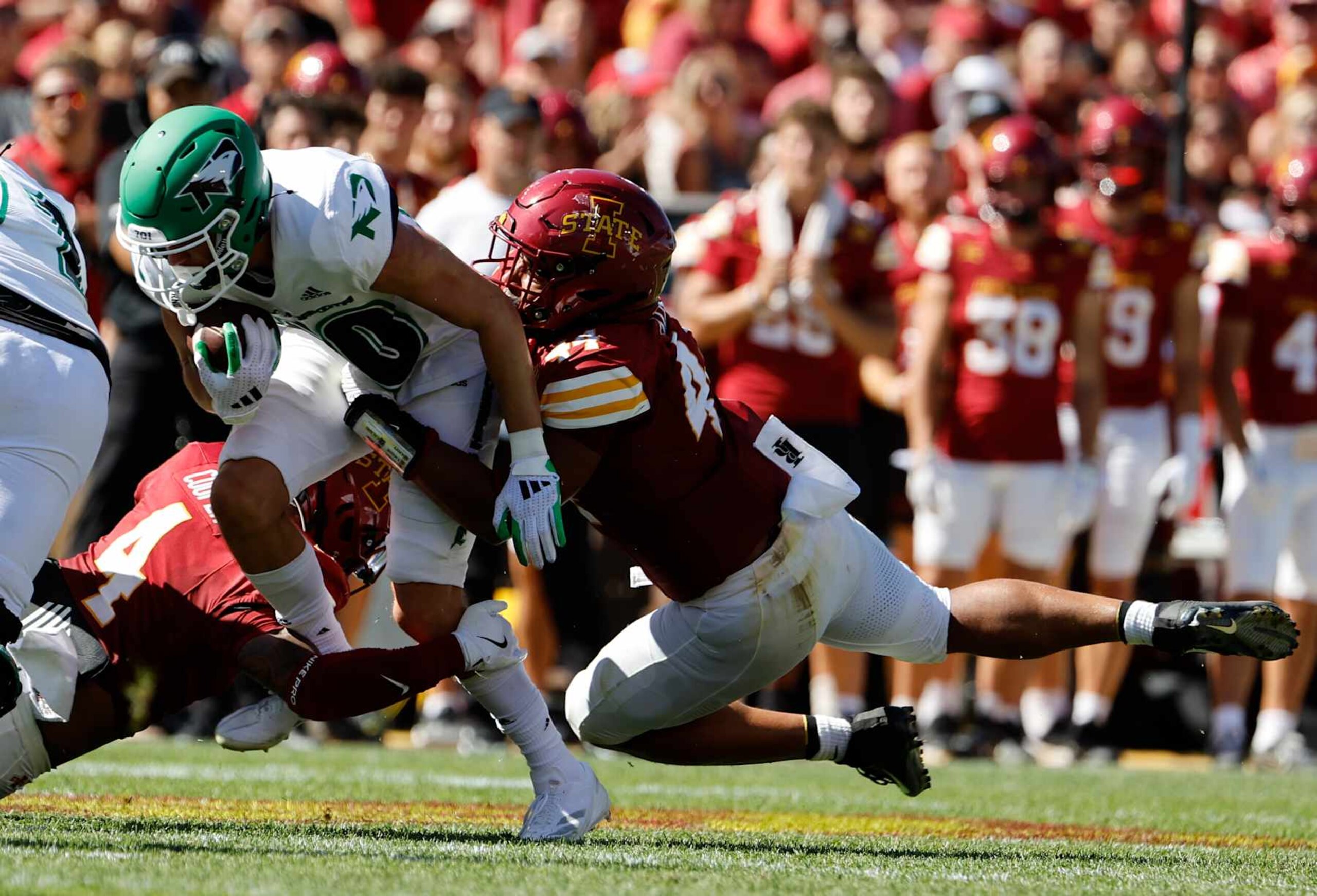 AMES, IA - AUGUST 31: Running back Sawyer Seidl #20 of the North Dakota Fighting Hawks is tackled by defensive back Jeremiah Cooper #4, and linebacker Jacob Ellis #44 of the Iowa State Cyclones as he rushed for yards in the first half of play at Jack Trice Stadium on August 31, 2024, in Ames, Iowa. (Photo by David Purdy/Getty Images)