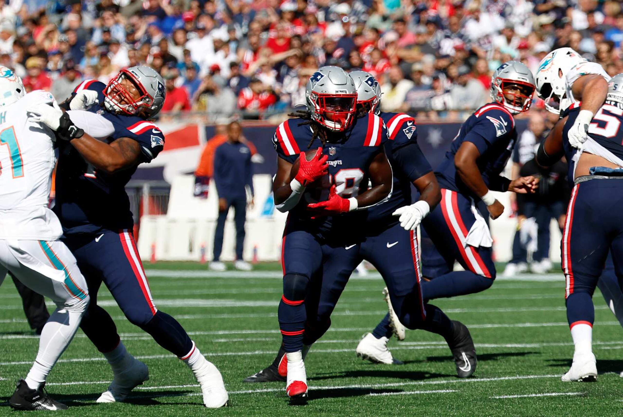 FOXBOROUGH, MA - OCTOBER 06: New England Patriots running back Rhamondre Stevenson (38) breaks through the line during a game between the New England Patriots and the Miami Dolphins on October 6, 2024, at Gillette Stadium in Foxborough, Massachusetts. (Photo by Fred Kfoury III/Icon Sportswire via Getty Images) FOXBOROUGH, MA - OCTOBER 06: New England Patriots running back Rhamondre Stevenson (38) breaks through the line during a game between the New England Patriots and the Miami Dolphins on October 6, 2024, at Gillette Stadium in Foxborough, Massachusetts. (Photo by Fred Kfoury III/Icon Sportswire via Getty Images)