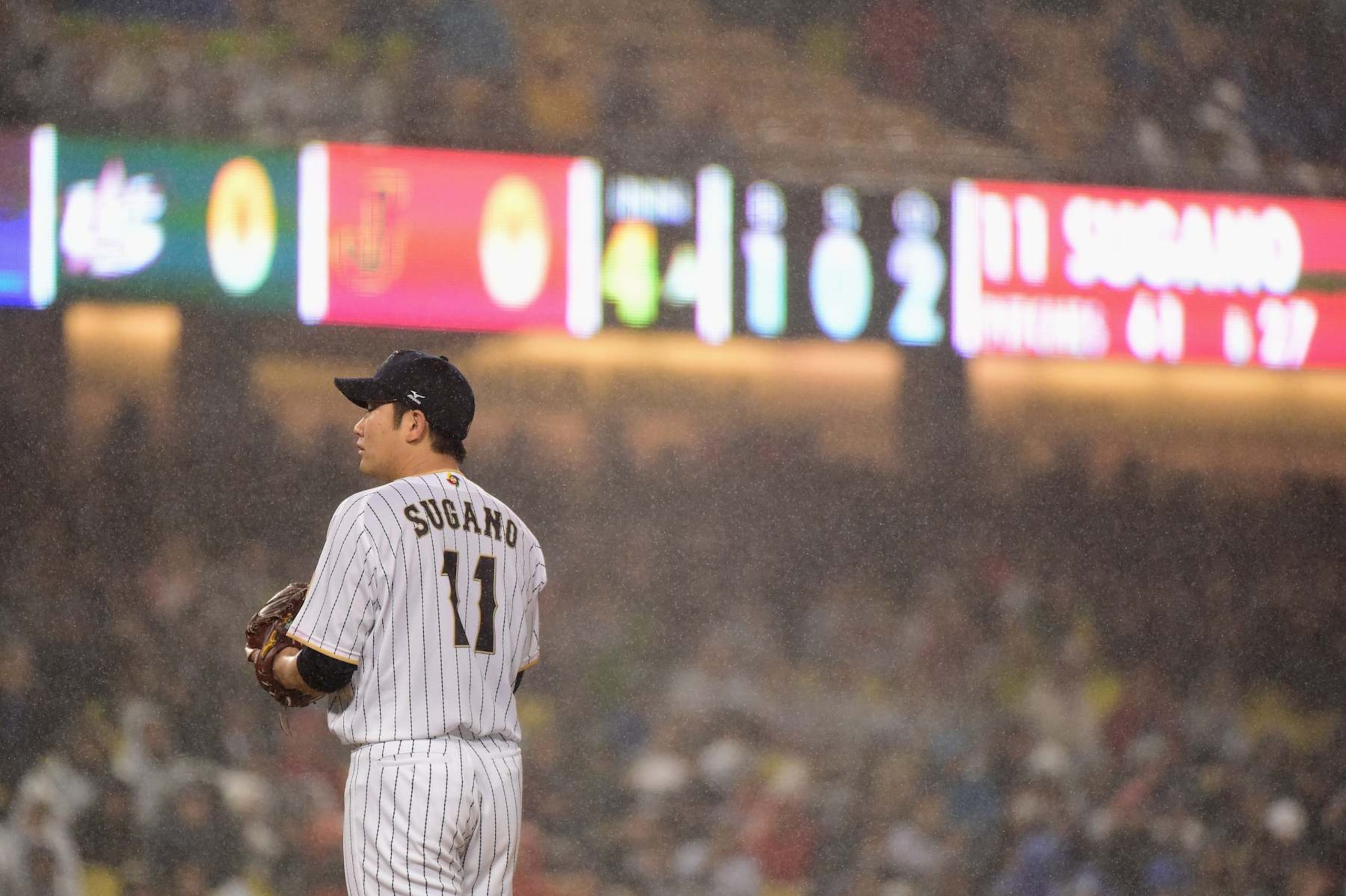 LOS ANGELES, CA - MARCH 21: Tomoyuki Sugano #11 of team Japan looks on in the rain during the fourth inning against team United States during Game 2 of the Championship Round of the 2017 World Baseball Classic at Dodger Stadium on March 21, 2017 in Los Angeles, California.  (Photo by Harry How/Getty Images)