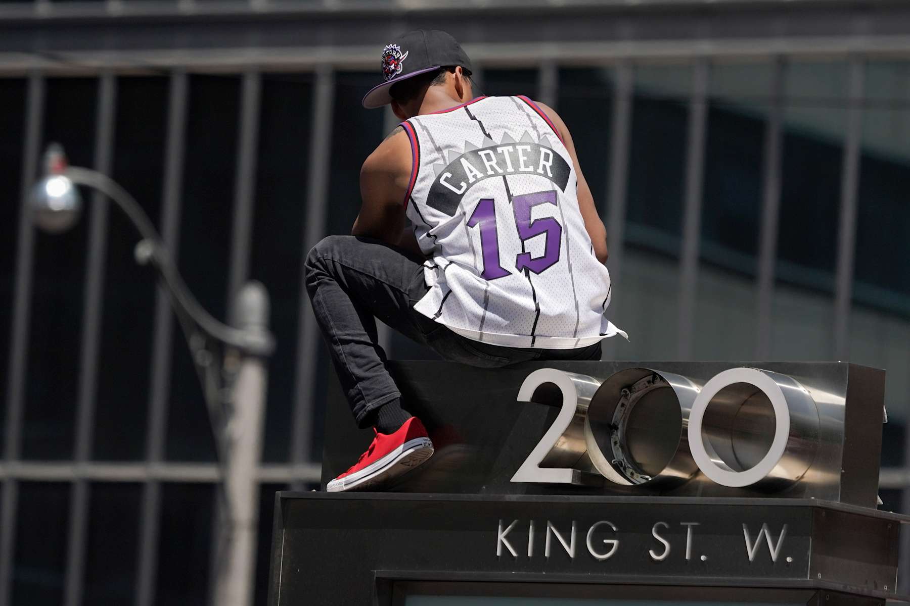 TORONTO, ON - JUNE 17: A fan with an older Raptors Vince Carter (15) Jersey sits high on  traffic light he climbed up on during the Toronto Raptors 2019 NBA Championship Parade on June 17, 2019, in Toronto, ON. (Photo by Jeff Chevrier/Icon Sportswire via Getty Images)