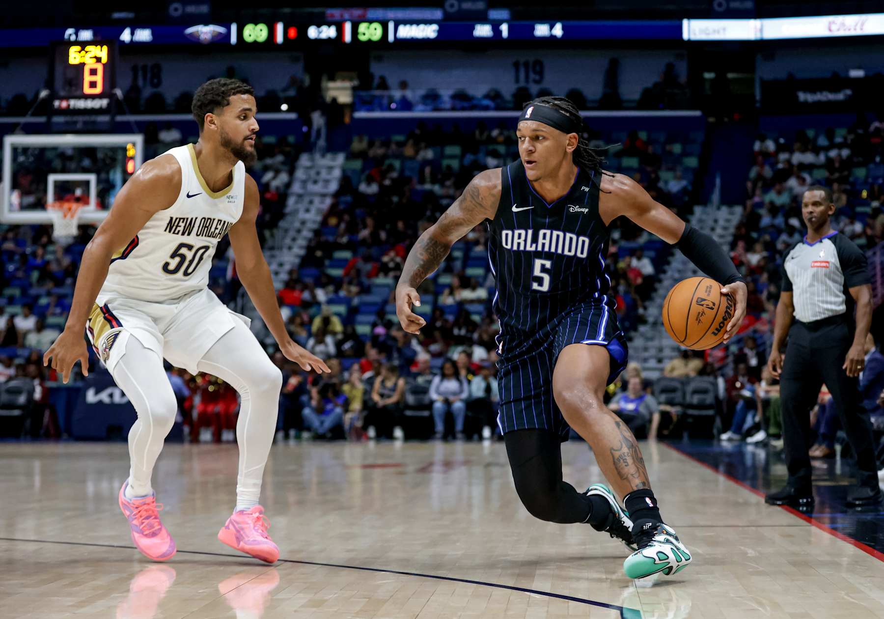 NEW ORLEANS, LOUISIANA - OCTOBER 7:  Paolo Banchero #5 of the Orlando Magic is defended by Jeremiah Robinson-Earl #50 of the New Orleans Pelicans during the second half of a preseason game at the Smoothie King Center on October 7, 2024 in New Orleans, Louisiana. NOTE TO USER: User expressly acknowledges and agrees that, by downloading and or using this photograph, User is consenting to the terms and conditions of the Getty Images License Agreement. (Photo by Derick E. Hingle/Getty Images)