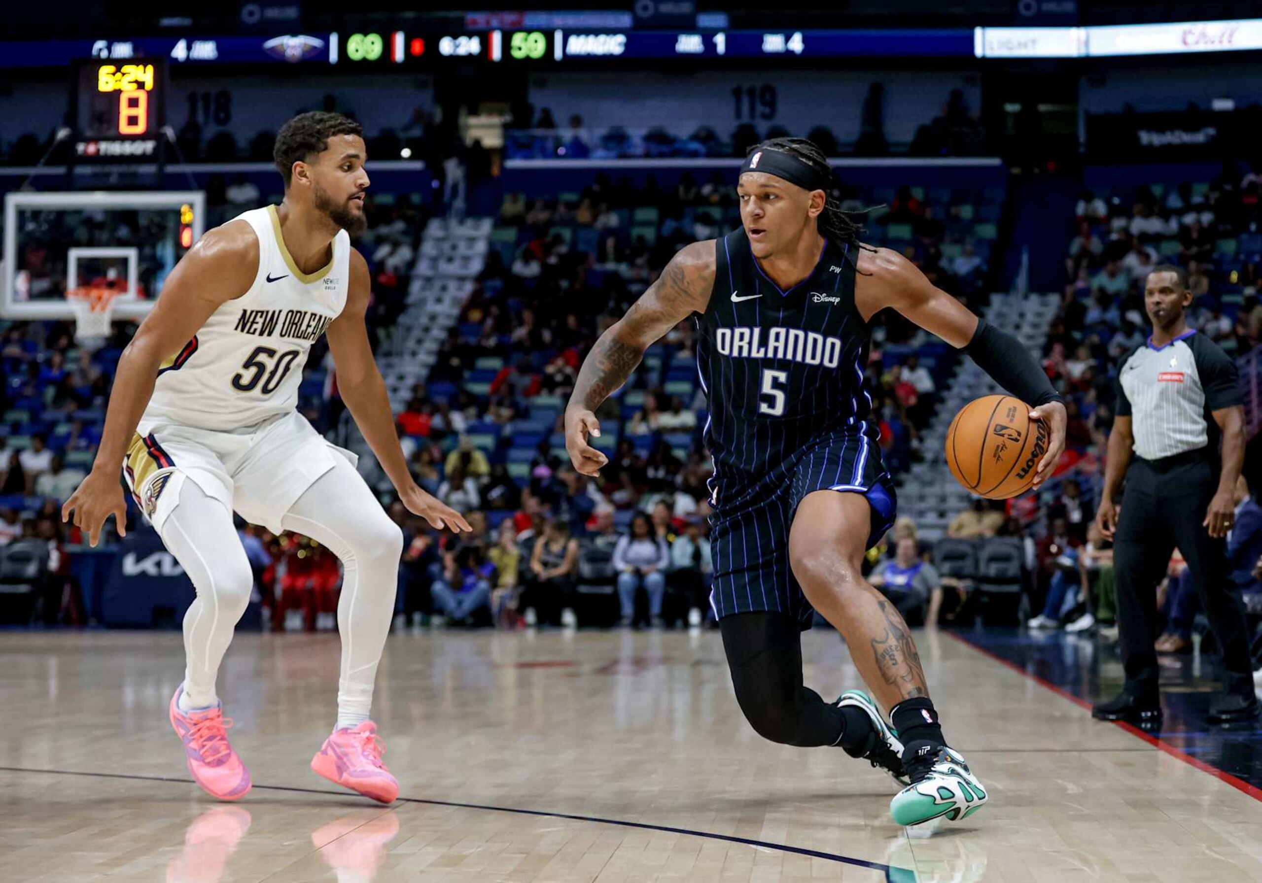NEW ORLEANS, LOUISIANA - OCTOBER 7:  Paolo Banchero #5 of the Orlando Magic is defended by Jeremiah Robinson-Earl #50 of the New Orleans Pelicans during the second half of a preseason game at the Smoothie King Center on October 7, 2024 in New Orleans, Louisiana. NOTE TO USER: User expressly acknowledges and agrees that, by downloading and or using this photograph, User is consenting to the terms and conditions of the Getty Images License Agreement. (Photo by Derick E. Hingle/Getty Images)