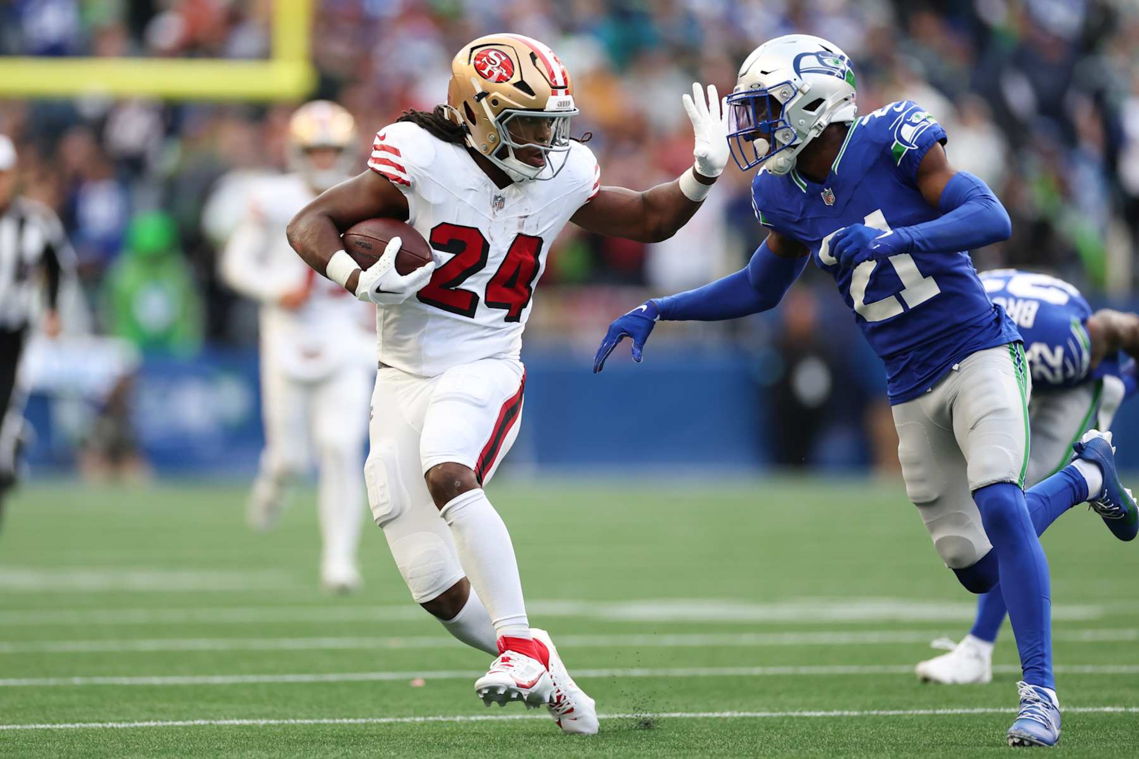 SEATTLE, WASHINGTON - OCTOBER 10: Jordan Mason #24 of the San Francisco 49ers runs the ball against Devon Witherspoon #21 of the Seattle Seahawks during the first quarter at Lumen Field on October 10, 2024 in Seattle, Washington. (Photo by Steph Chambers/Getty Images) SEATTLE, WASHINGTON - OCTOBER 10: Jordan Mason #24 of the San Francisco 49ers runs the ball against Devon Witherspoon #21 of the Seattle Seahawks during the first quarter at Lumen Field on October 10, 2024 in Seattle, Washington. (Photo by Steph Chambers/Getty Images)