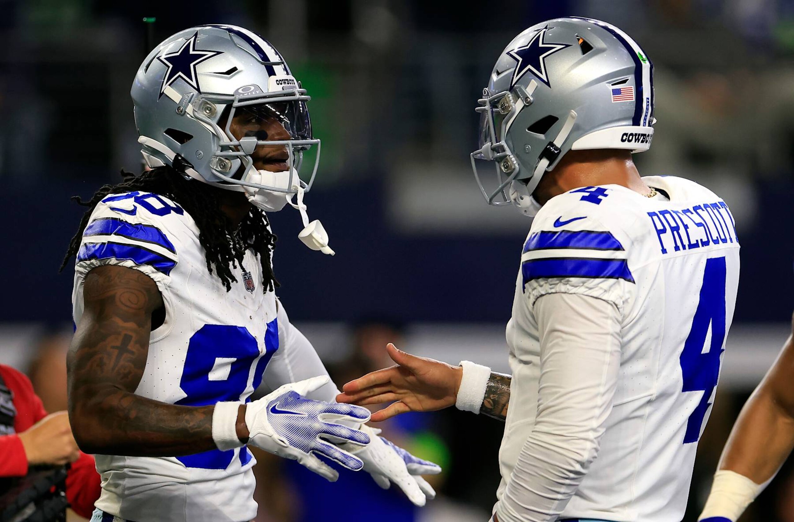ARLINGTON, TEXAS - NOVEMBER 30:  Wide receiver CeeDee Lamb #88 of the Dallas Cowboys is congratulated by quarterback Dak Prescott #4 after catching a pass in the end zone for a touchdown during the 1st quarter of the game against the Seattle Seahawks at AT&T Stadium on November 30, 2023 in Arlington, Texas. (Photo by Ron Jenkins/Getty Images)