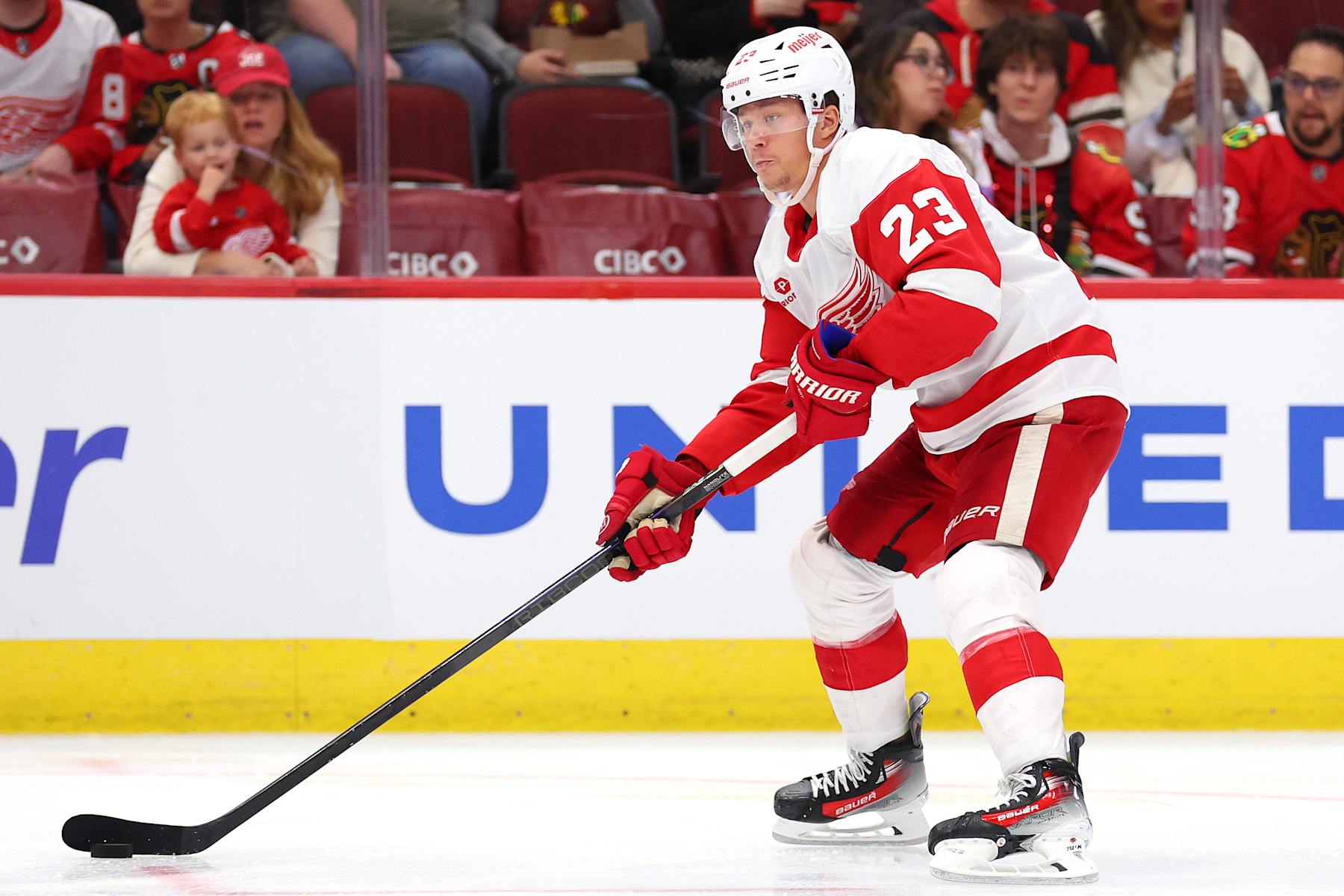 CHICAGO, ILLINOIS - SEPTEMBER 25: Lucas Raymond #23 of the Detroit Red Wings skates with the puck against the Chicago Blackhawks during the third period of a preseason game at the United Center on September 25, 2024 in Chicago, Illinois.  (Photo by Michael Reaves/Getty Images)