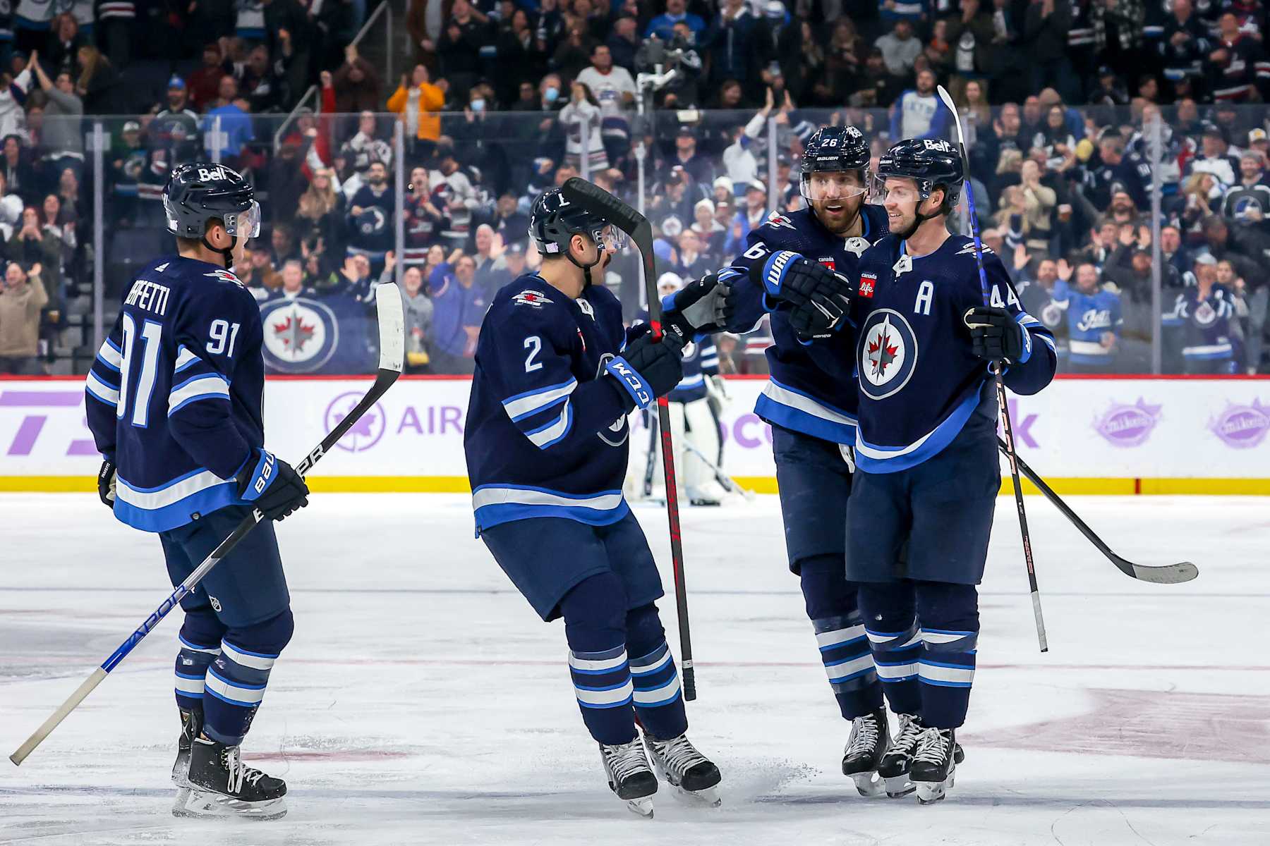 WINNIPEG, CANADA - NOVEMBER 29: Cole Perfetti #91, Dylan DeMelo #2, Blake Wheeler #26 and Josh Morrissey #44 of the Winnipeg Jets celebrate a second period goal against the Colorado Avalanche at the Canada Life Centre on November 29, 2022 in Winnipeg, Manitoba, Canada. (Photo by Jonathan Kozub/NHLI via Getty Images)