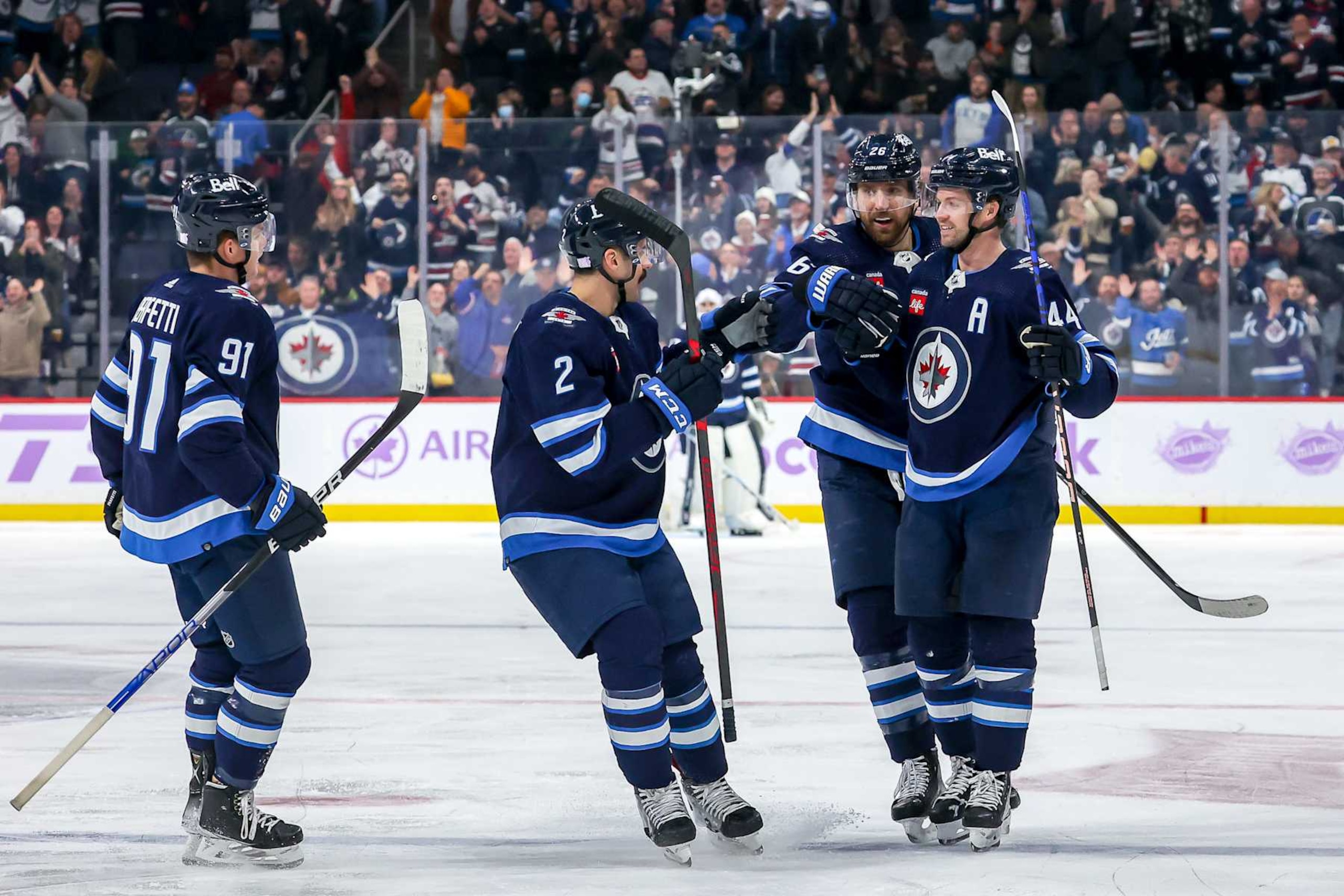 WINNIPEG, CANADA - NOVEMBER 29: Cole Perfetti #91, Dylan DeMelo #2, Blake Wheeler #26 and Josh Morrissey #44 of the Winnipeg Jets celebrate a second period goal against the Colorado Avalanche at the Canada Life Centre on November 29, 2022 in Winnipeg, Manitoba, Canada. (Photo by Jonathan Kozub/NHLI via Getty Images)