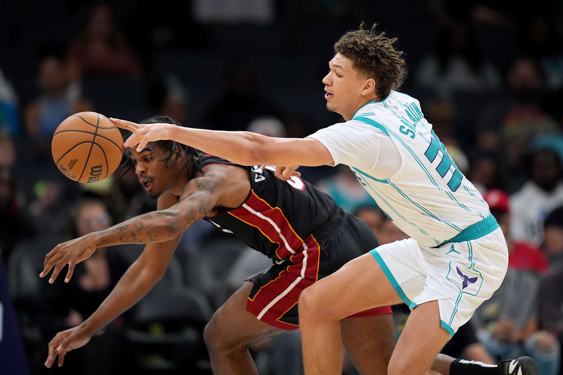 CHARLOTTE, NORTH CAROLINA - OCTOBER 08: Josh Christopher #8 of the Miami Heat battles Tidjane Salaun #31 of the Charlotte Hornets for a loose ball during the second half of the preseason game at Spectrum Center on October 08, 2024 in Charlotte, North Carolina. NOTE TO USER: User expressly acknowledges and agrees that, by downloading and or using this photograph, User is consenting to the terms and conditions of the Getty Images License Agreement. (Photo by Grant Halverson/Getty Images)