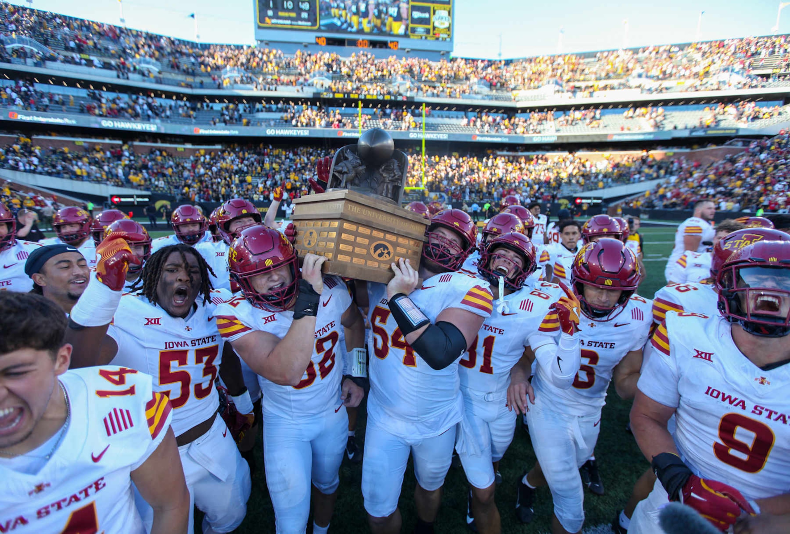 The Iowa State Cyclones celebrate their Cy-Hawk Trophy win.