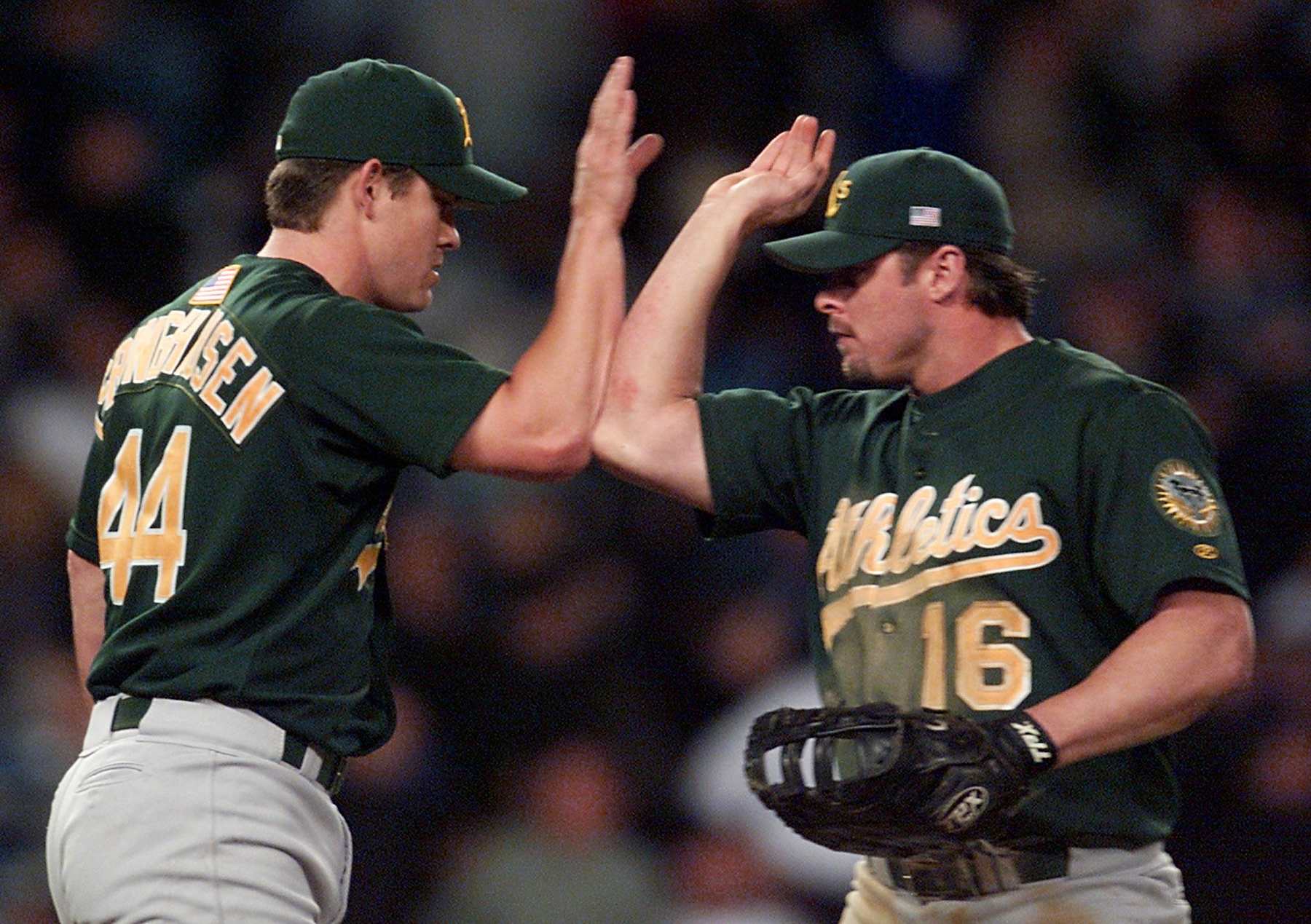 NEW YORK, UNITED STATES:  Oakland Athletics Jason Giambi (R) high fives teammate Jason Isringhausen after the A's beat the New York Yankees in the American League Division Series game one against the New York Yankees, 10 October, 2001, at Yankee Stadium in New York. The Athletics won the game 5-3.   AFP PHOTO/Timothy CLARY (Photo credit should read TIMOTHY A. CLARY/AFP via Getty Images)