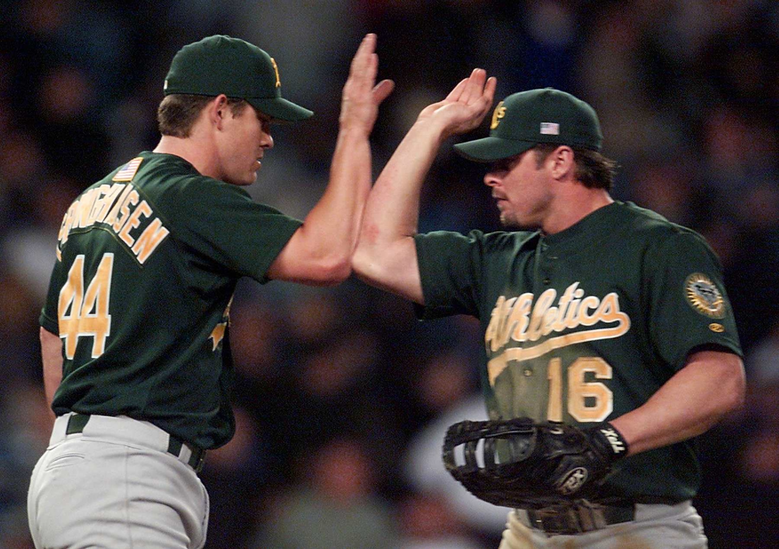 NEW YORK, UNITED STATES:  Oakland Athletics Jason Giambi (R) high fives teammate Jason Isringhausen after the A's beat the New York Yankees in the American League Division Series game one against the New York Yankees, 10 October, 2001, at Yankee Stadium in New York. The Athletics won the game 5-3.   AFP PHOTO/Timothy CLARY (Photo credit should read TIMOTHY A. CLARY/AFP via Getty Images)