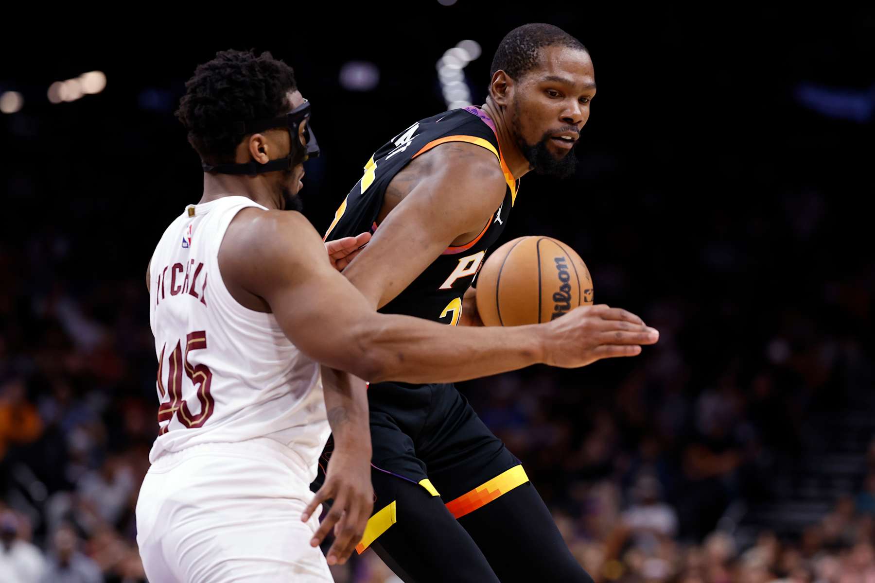 PHOENIX, ARIZONA - APRIL 03: Kevin Durant #35 of the Phoenix Suns posts up on Donovan Mitchell #45 of the Cleveland Cavaliers during the game at Footprint Center on April 03, 2024 in Phoenix, Arizona. The Suns defeated the Cavaliers 122-101. NOTE TO USER: User expressly acknowledges and agrees that, by downloading and or using this photograph, User is consenting to the terms and conditions of the Getty Images License Agreement.  (Photo by Chris Coduto/Getty Images)