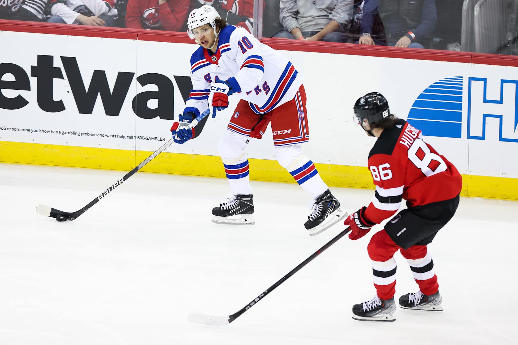 NEWARK, NJ - APRIL 20: New York Rangers left wing Artemi Panarin (10) skates with the puck while being chased by New Jersey Devils center Jack Hughes (86) during the National Hockey League game between the New York Rangers and the New Jersey Devils on April 20, 2023 at Prudential Center in Newark, NJ. (Photo by Andrew Mordzynski/Icon Sportswire via Getty Images)