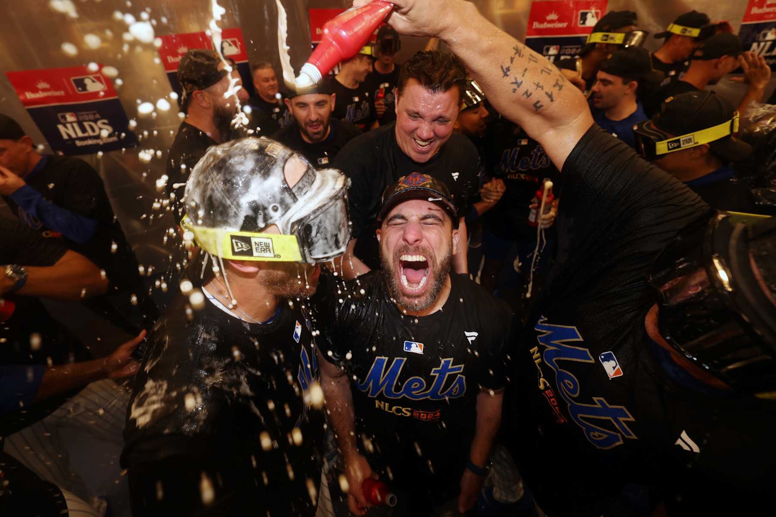 NEW YORK, NEW YORK - OCTOBER 09: The New York Mets celebrate in the locker room after beating the Philadelphia Phillies 4-1 in Game Four of the Division Series at Citi Field on October 09, 2024 in New York City. (Photo by Luke Hales/Getty Images)