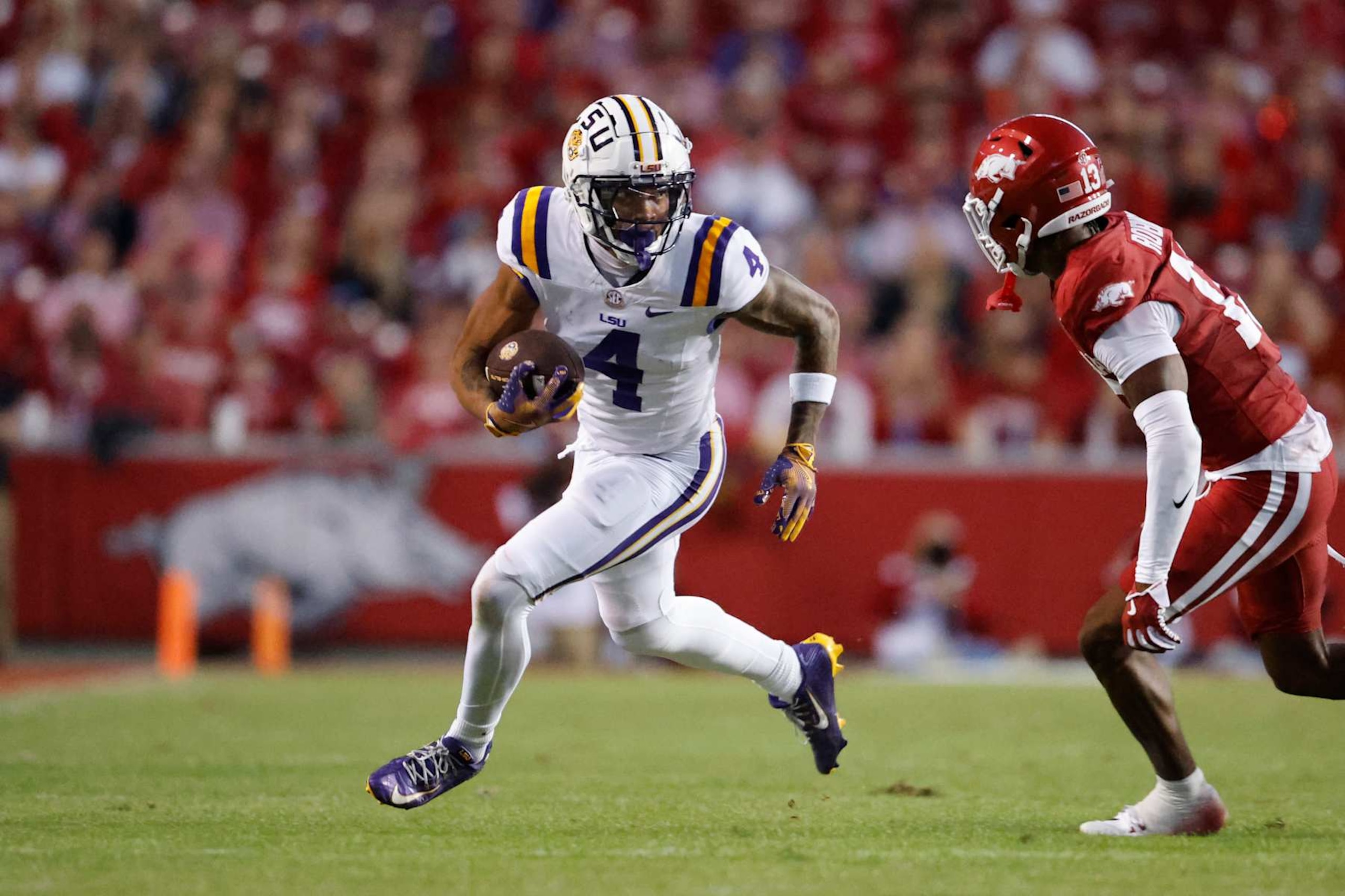 FAYETTEVILLE, AR - OCTOBER 19:  LSU Tigers wide receiver CJ Daniels (4) runs with the football as Arkansas Razorbacks defensive back Marquise Robinson (13) attempts to make a tackle during the college football game between the LSU Tigers and Arkansas Razorbacks on October 19, 2024, at Donald W. Reynolds Razorback Stadium in Fayetteville, Arkansas. (Photo by Andy Altenburger/Icon Sportswire via Getty Images)