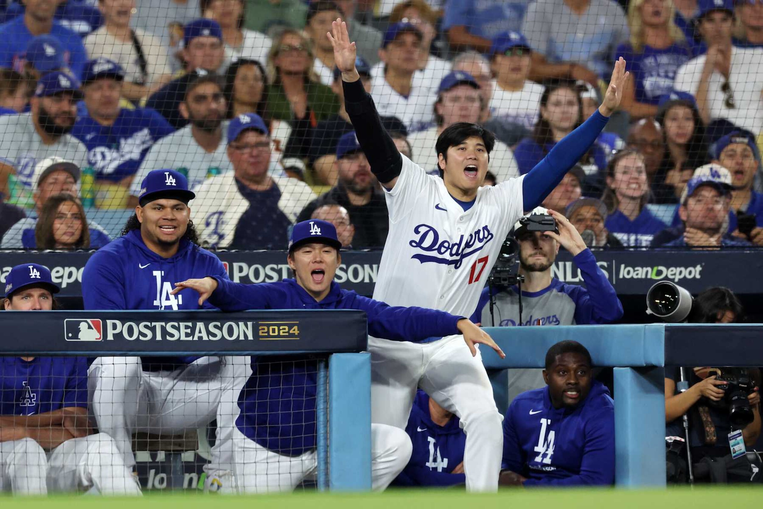 LOS ANGELES, CALIFORNIA - OCTOBER 20:  Brusdar Graterol #48, Yoshinobu Yamamoto #18 and Shohei Ohtani #17 of the Los Angeles Dodgers react to a close call on first base during the 5th inning of Game Six of the National League Championship Series against the New York Mets at Dodger Stadium on October 20, 2024 in Los Angeles, California. (Photo by Harry How/Getty Images)