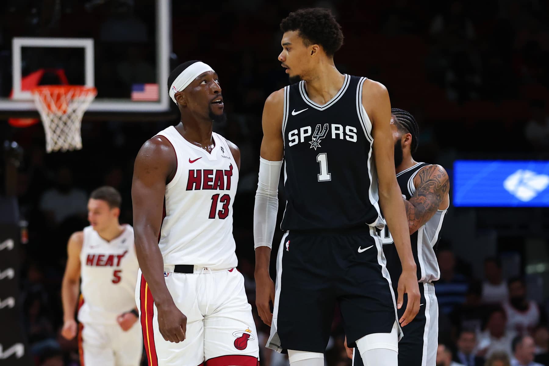 MIAMI, FLORIDA - OCTOBER 15: Bam Adebayo #13 of the Miami Heat and Victor Wembanyama #1 of the San Antonio Spurs reacts during the first quarter of a preseason game at Kaseya Center on October 15, 2024 in Miami, Florida. NOTE TO USER: User expressly acknowledges and agrees that, by downloading and or using this photograph, User is consenting to the terms and conditions of the Getty Images License Agreement. (Photo by Megan Briggs/Getty Images)