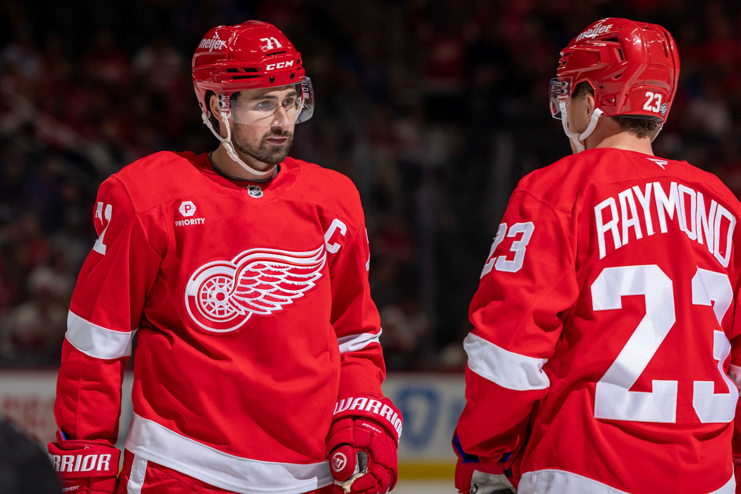 DETROIT, MICHIGAN - OCTOBER 17: Dylan Larkin #71 of the Detroit Red Wings talks to Lucas Raymond #23 before the face off against the New York Rangers during the first period at Little Caesars Arena on October 17, 2024 in Detroit, Michigan. (Photo by Dave Reginek/NHLI via Getty Images)