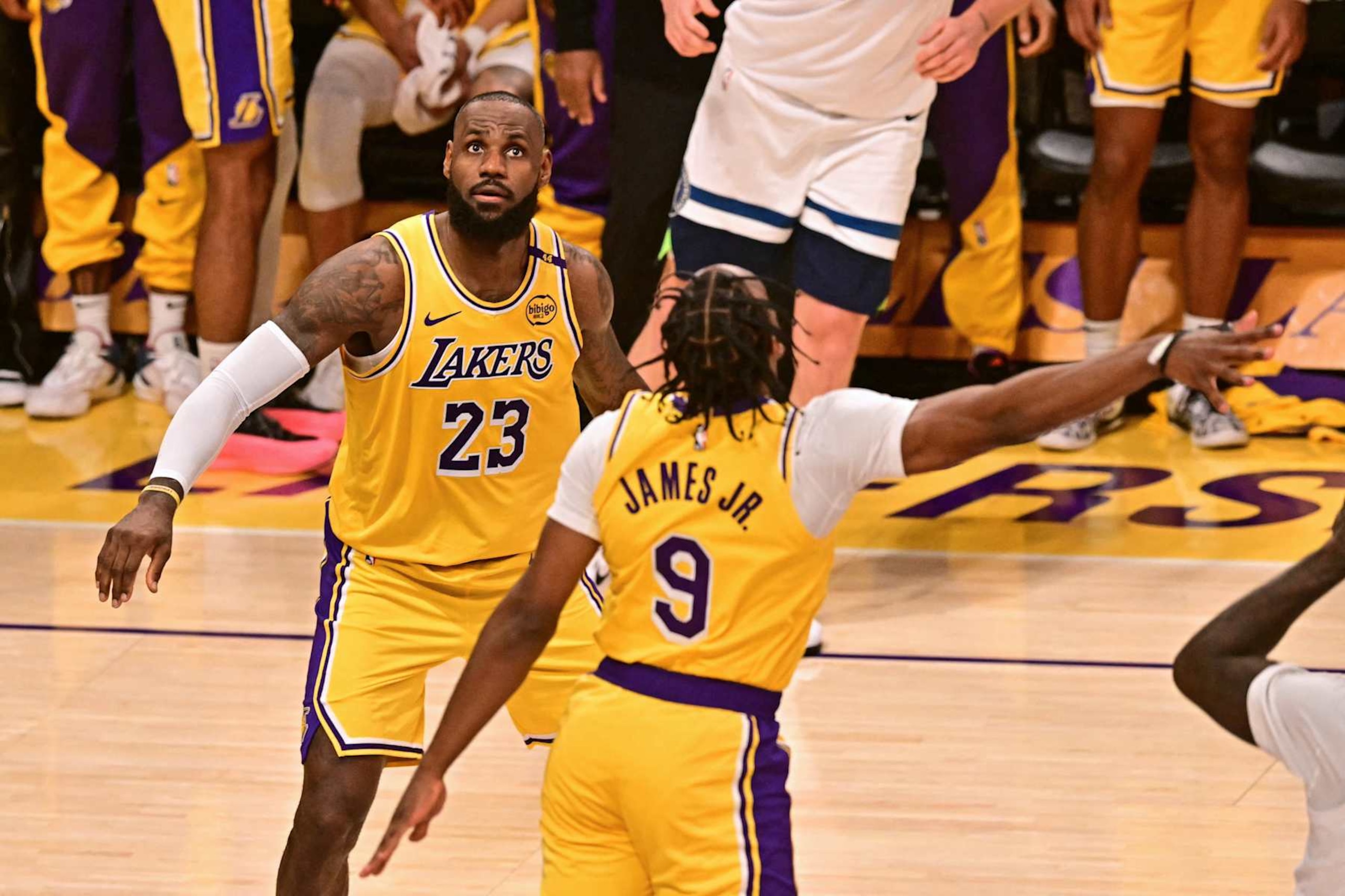 Los Angeles Lakers' US guard #09 Bronny James  jumps to block a shot as Los Angeles Lakers' US small forward #23 LeBron James looks on during the NBA game season opener between the Los Angeles Lakers and the Minnesota Timberwolves at Crypto Arena in Los Angeles on October 22, 2024. LeBron and Bronny are the first father and son to play together in any NBA game. (Photo by Frederic J. Brown / AFP) (Photo by FREDERIC J. BROWN/AFP via Getty Images)