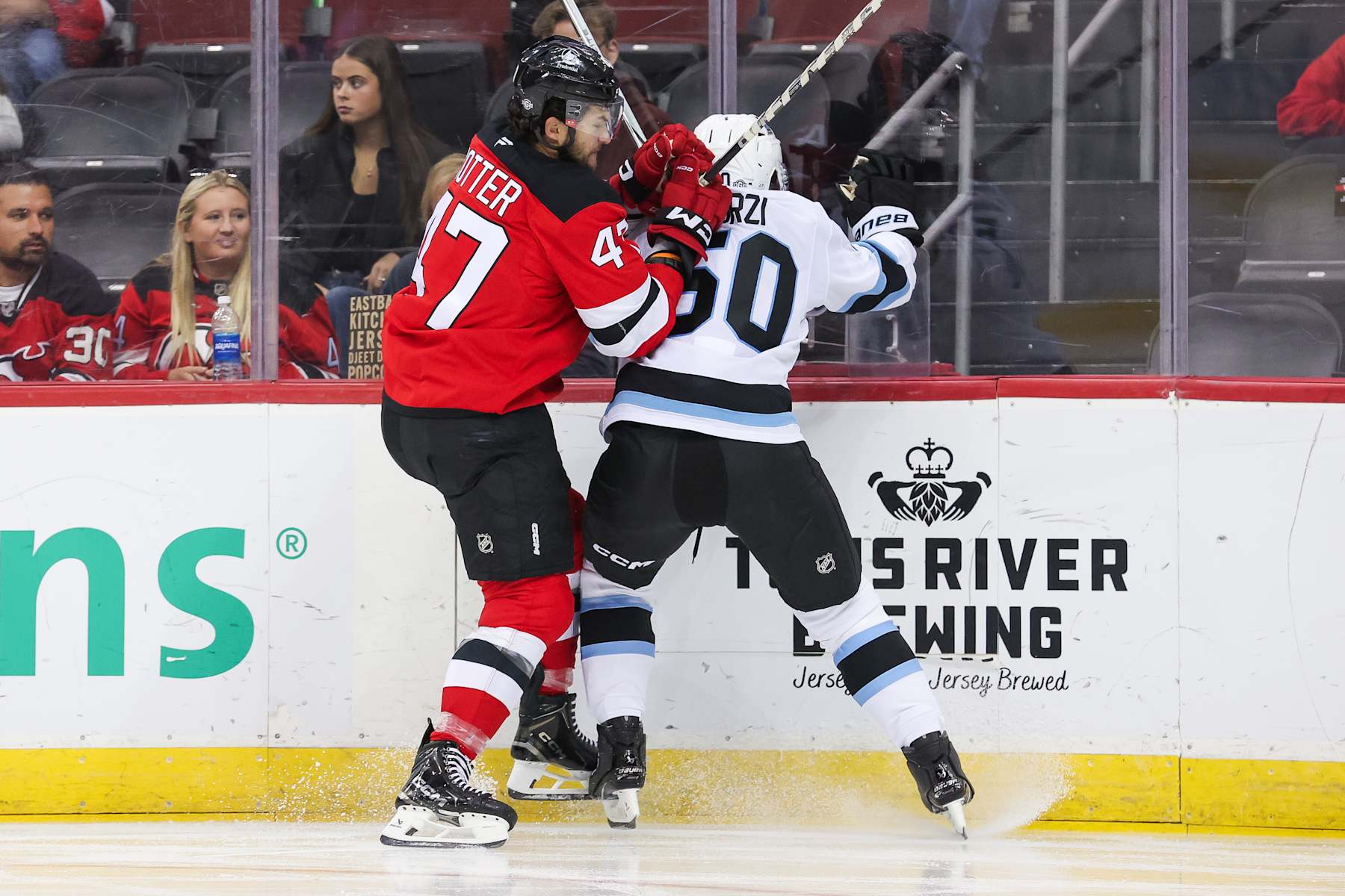 NEWARK, NJ - OCTOBER 14: New Jersey Devils center Paul Cotter (47) hits Utah Hockey Club defenseman Sean Durzi (50) during a game between the Utah Hockey Club and New Jersey Devils on October 14, 2024 at Prudential Center in Newark, New Jersey. (Photo by Andrew Mordzynski/Icon Sportswire via Getty Images)