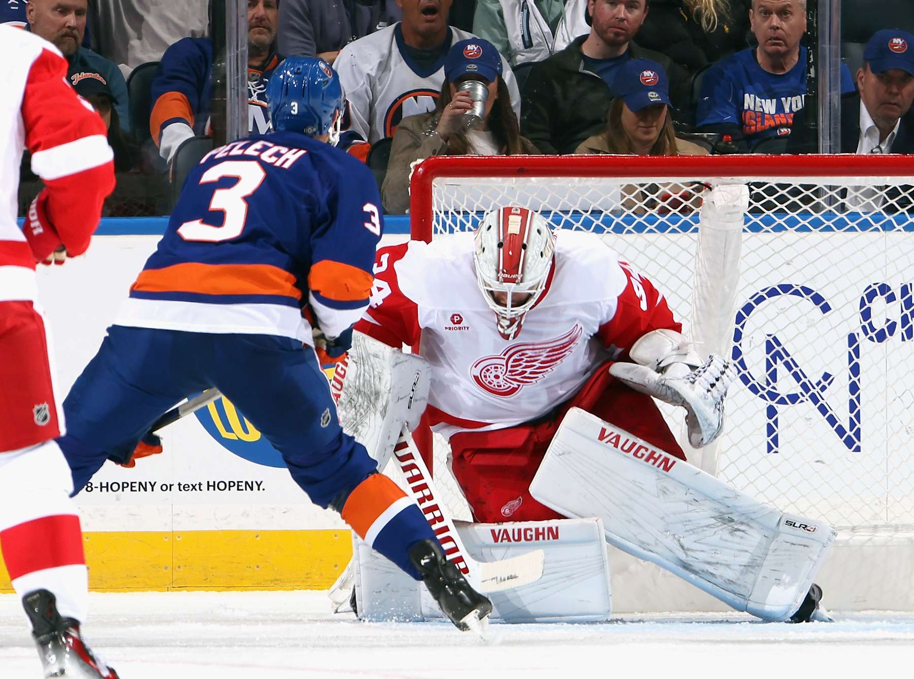 ELMONT, NEW YORK - OCTOBER 22: Alex Lyon #34 of the Detroit Red Wings makes a first period save on Adam Pelech #3 of the New York Islanders at UBS Arena on October 22, 2024 in Elmont, New York. (Photo by Bruce Bennett/Getty Images)