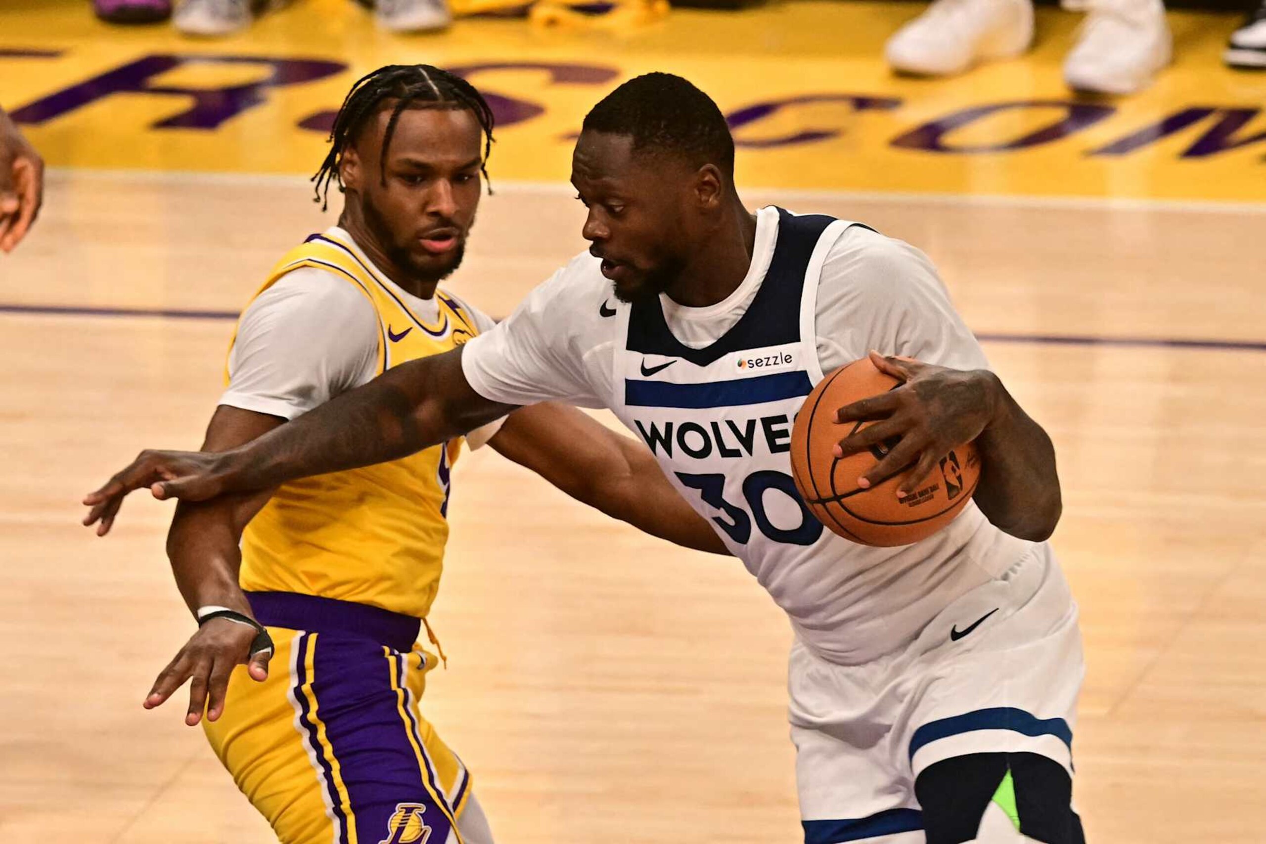 Minnesota Timberwolves' US power forward #30 Julius Randle dribbles past Los Angeles Lakers' US guard #09 Bronny James during the NBA game season opener between the Los Angeles Lakers and the Minnesota Timberwolves at Crypto Arena in Los Angeles on October 22, 2024. (Photo by Frederic J. Brown / AFP) (Photo by FREDERIC J. BROWN/AFP via Getty Images)