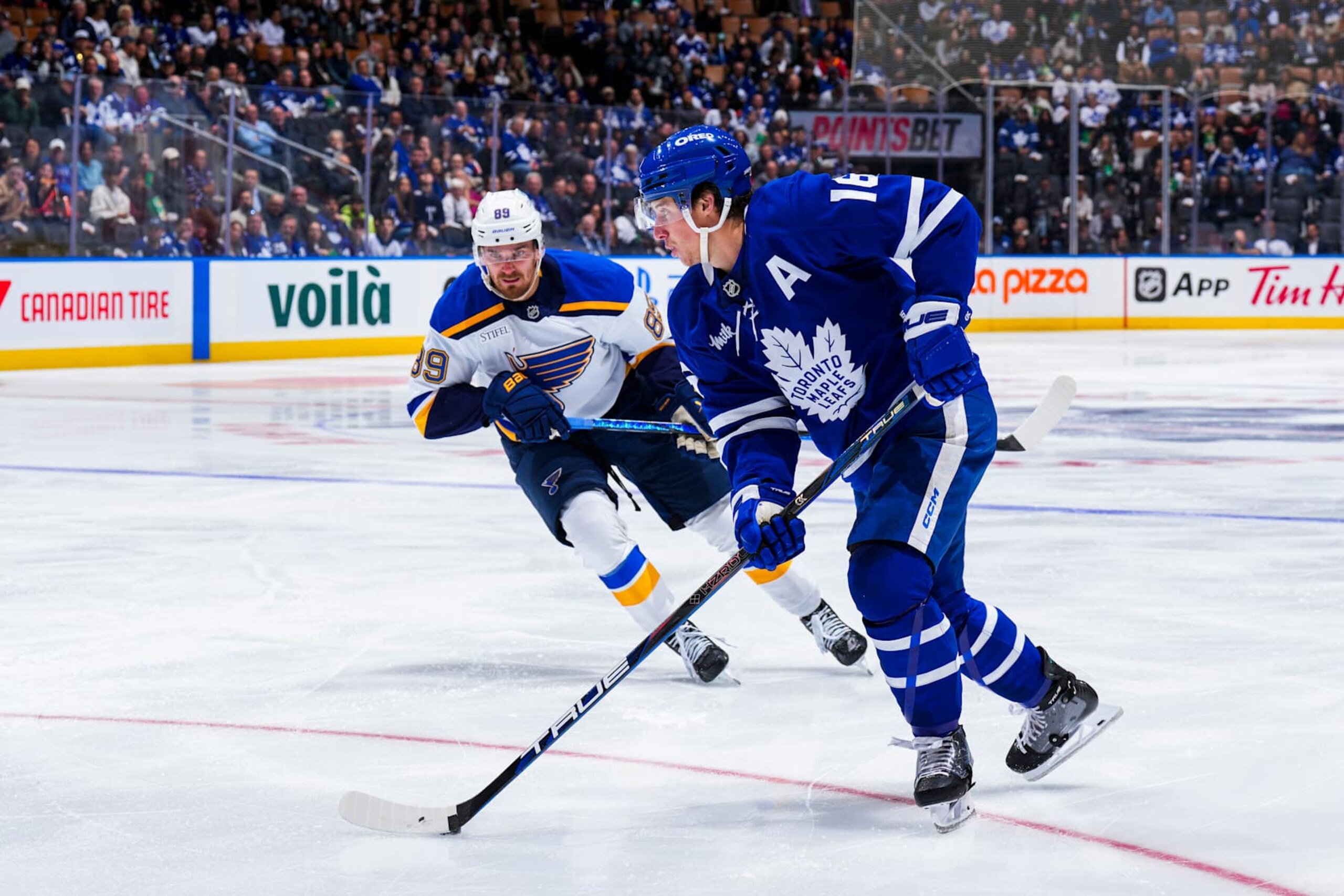 TORONTO, ON - OCTOBER 24: Mitch Marner #16 of the Toronto Maple Leafs plays the puck against Pavel Buchnevich #89 of the St. Louis Blues during the second period at the Scotiabank Arena on October 24, 2024 in Toronto, Ontario, Canada. (Photo by Kevin Sousa/NHLI via Getty Images) TORONTO, ON - OCTOBER 24: Mitch Marner #16 of the Toronto Maple Leafs plays the puck against Pavel Buchnevich #89 of the St. Louis Blues during the second period at the Scotiabank Arena on October 24, 2024 in Toronto, Ontario, Canada. (Photo by Kevin Sousa/NHLI via Getty Images)
