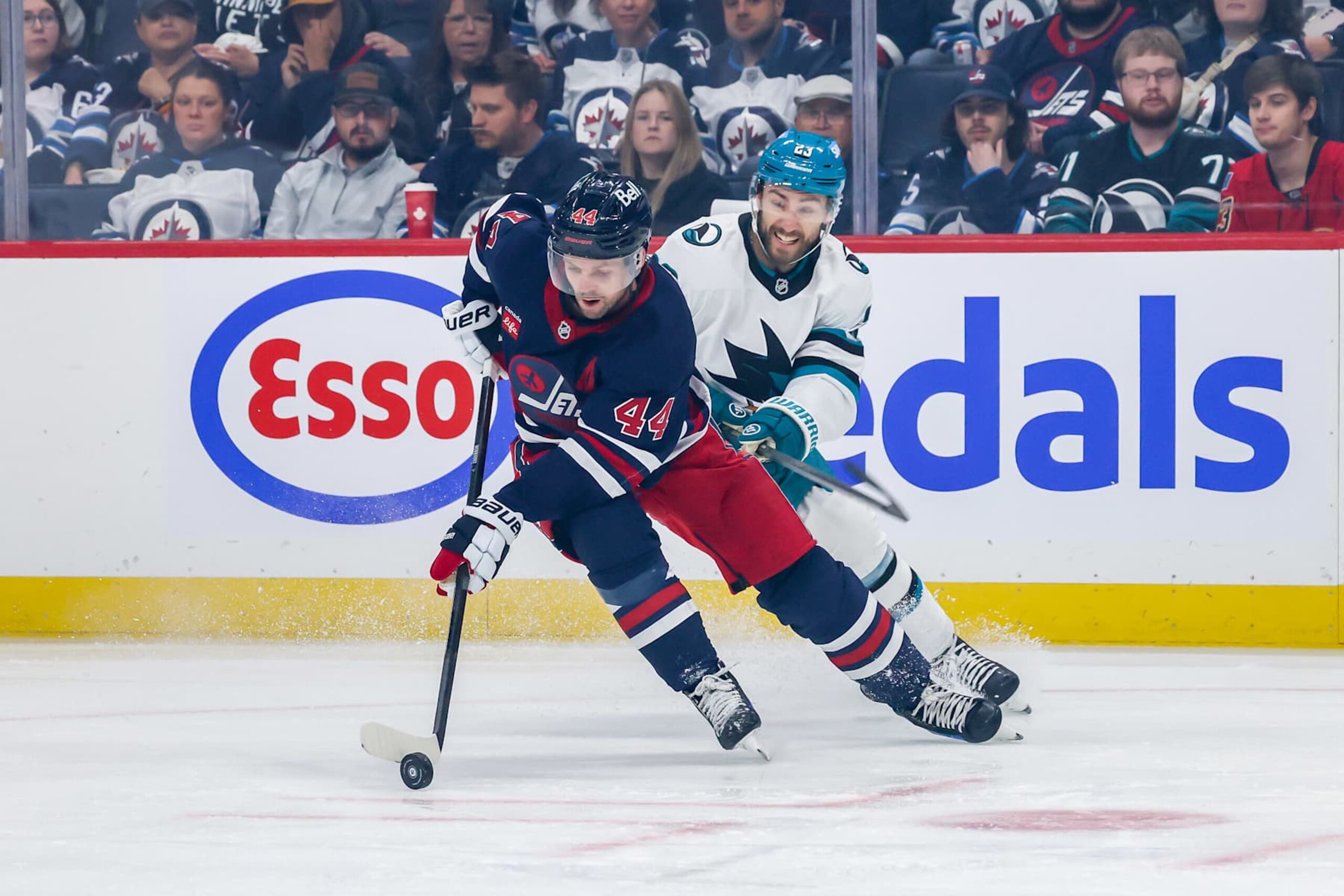 WINNIPEG, CANADA - OCTOBER 18: Josh Morrissey #44 of the Winnipeg Jets plays the puck up the ice as Barclay Goodrow #23 of the San Jose Sharks gives chase during first period action at the Canada Life Centre on October 18, 2024 in Winnipeg, Manitoba, Canada. (Photo by Jonathan Kozub/NHLI via Getty Images) WINNIPEG, CANADA - OCTOBER 18: Josh Morrissey #44 of the Winnipeg Jets plays the puck up the ice as Barclay Goodrow #23 of the San Jose Sharks gives chase during first period action at the Canada Life Centre on October 18, 2024 in Winnipeg, Manitoba, Canada. (Photo by Jonathan Kozub/NHLI via Getty Images)
