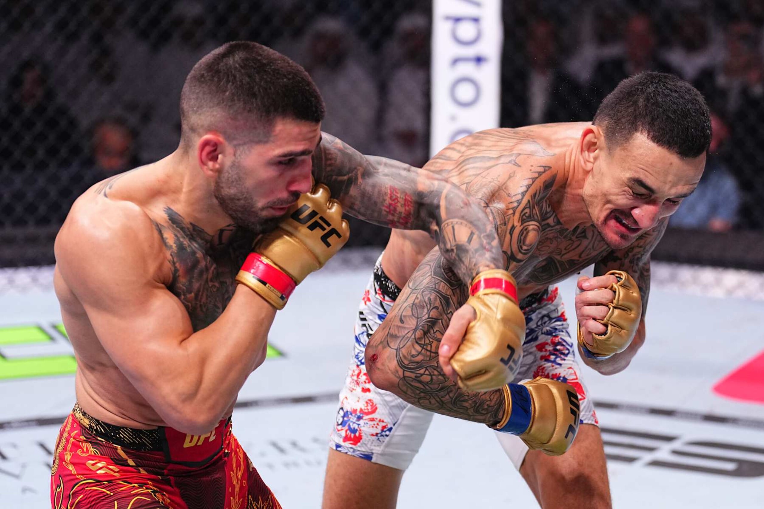 ABU DHABI, UNITED ARAB EMIRATES - OCTOBER 26: (L-R) Ilia Topuria of Spain punches Max Holloway in the UFC featherweight championship fight during the UFC 308 event at Etihad Arena on October 26, 2024 in Abu Dhabi, United Arab Emirates.  (Photo by Chris Unger/Zuffa LLC)