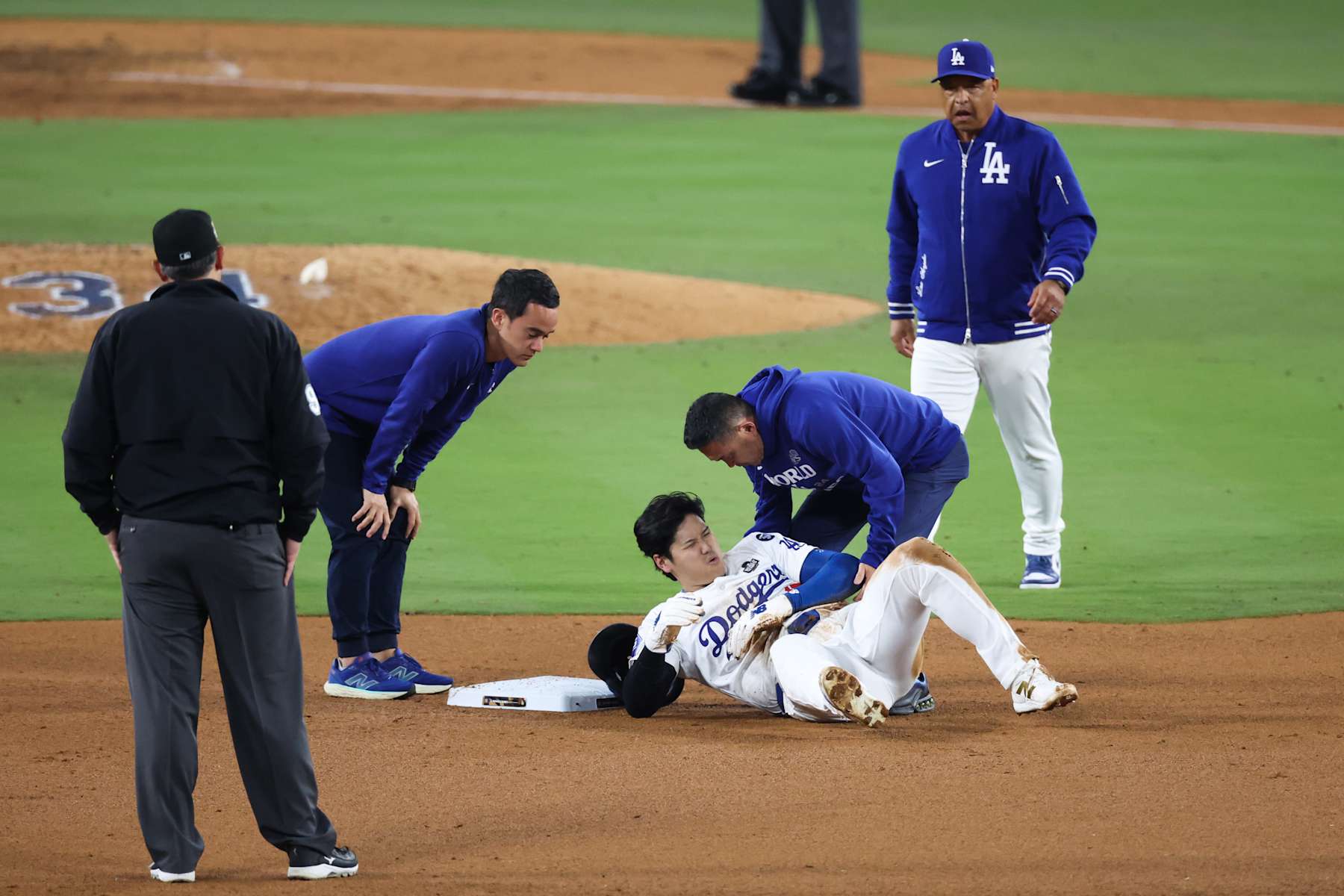 LOS ANGELES, CALIFORNIA - OCTOBER 26: Shohei Ohtani #17 of the Los Angeles Dodgers lies on the ground injured after attempting to steal second base as they play against the New York Yankees in the seventh inning during Game Two of the 2024 World Series at Dodger Stadium on October 26, 2024 in Los Angeles, California. (Photo by Steph Chambers/Getty Images)