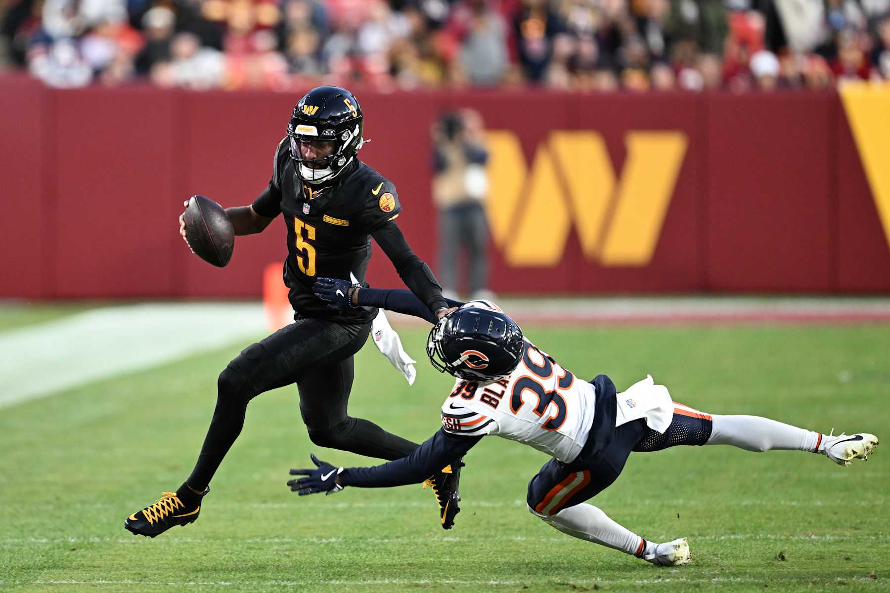 LANDOVER, MARYLAND - OCTOBER 27: Jayden Daniels #5 of the Washington Commanders carries the ball against Josh Blackwell #39 of the Chicago Bears during the third quarter at Northwest Stadium on October 27, 2024 in Landover, Maryland. (Photo by Greg Fiume/Getty Images)