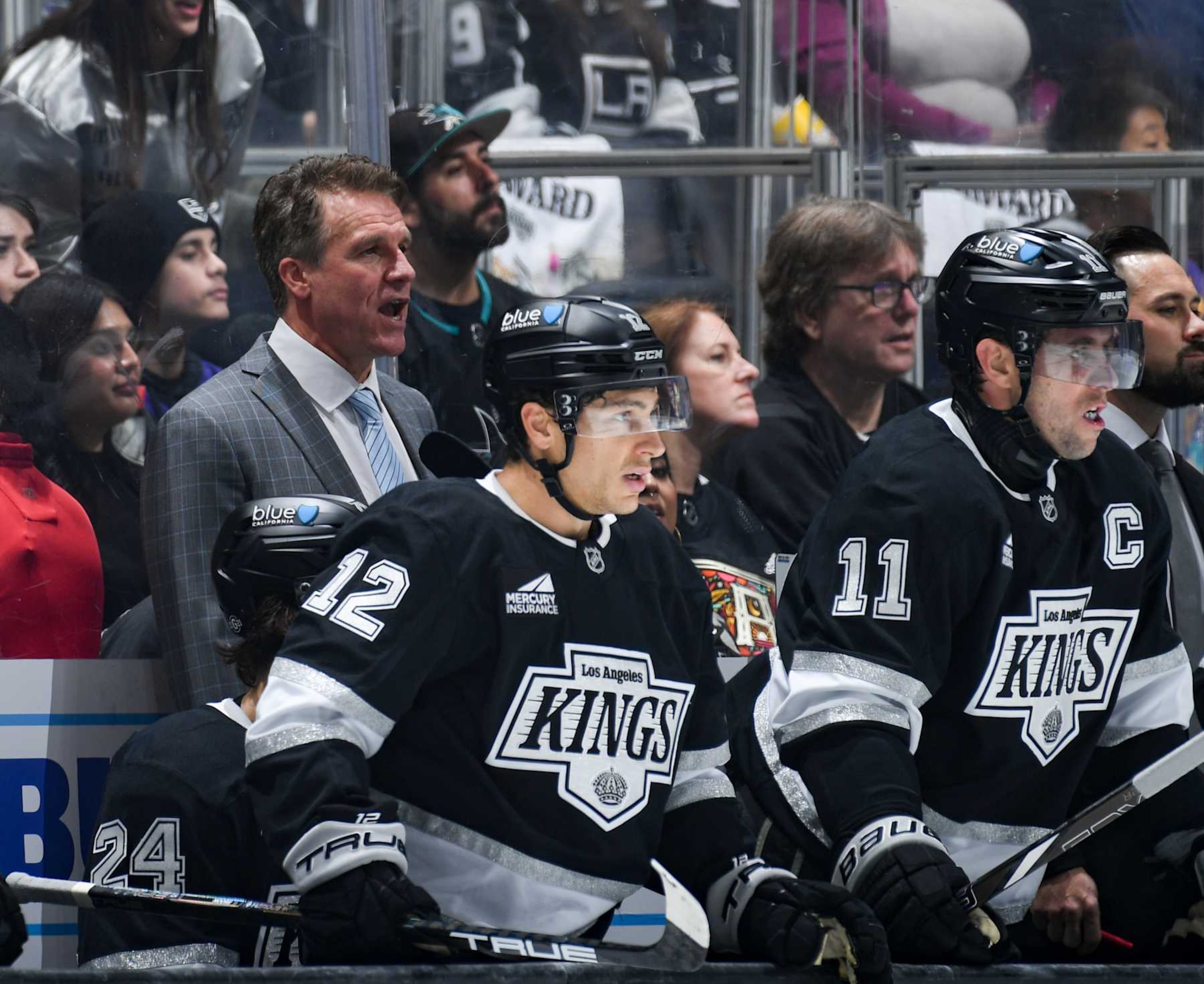 LOS ANGELES, CA - OCTOBER 24: Los Angeles Kings 
Jim Hiller, Trevor Moore #12 and Anze Kopitar #11 look on from the bench during the third period against the San Jose Sharks at Crypto.com Arena on October 24, 2024 in Los Angeles, California. (Photo by Juan Ocampo/NHLI via Getty Images)