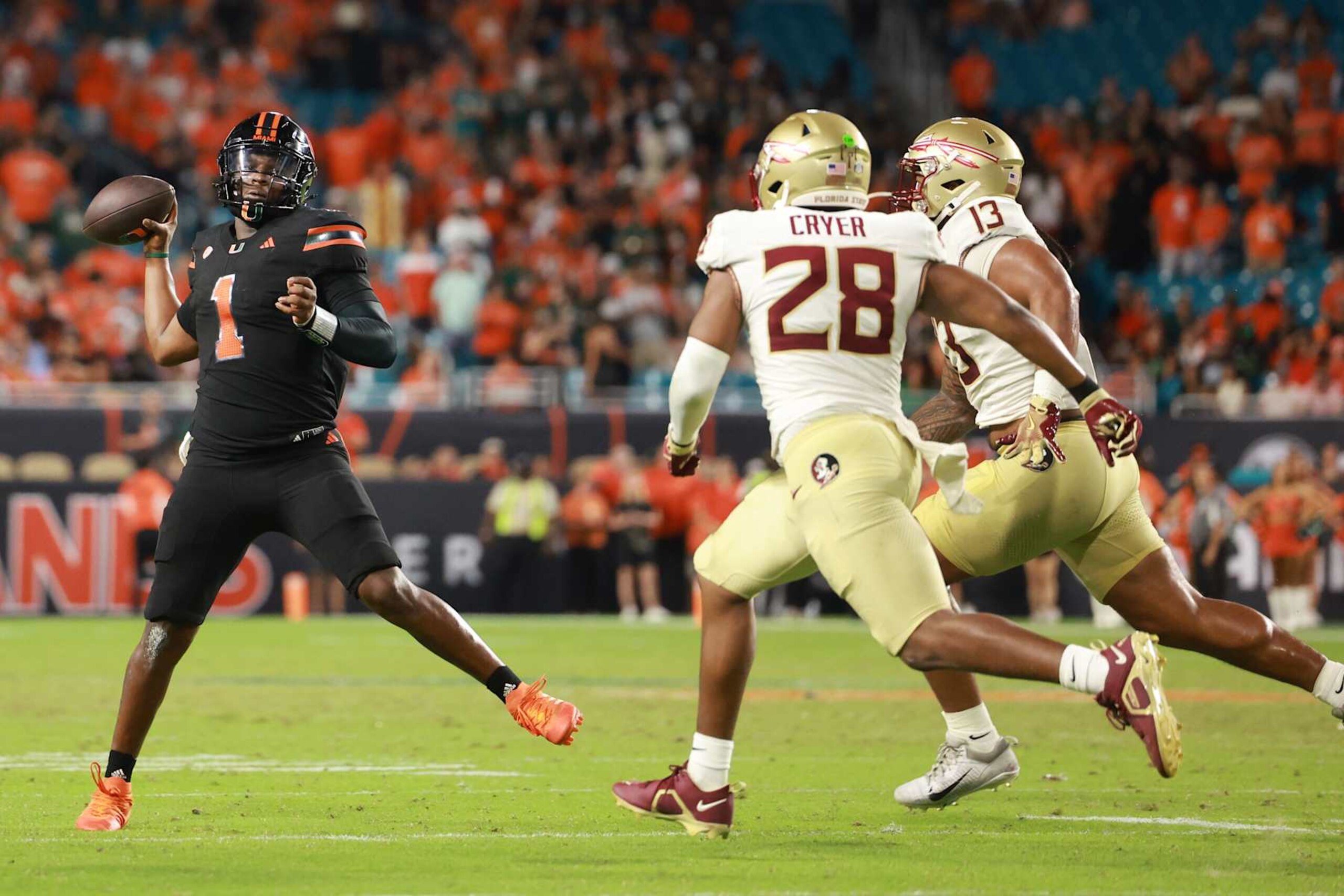MIAMI GARDENS, FLORIDA - OCTOBER 26: Cam Ward #1 of the Miami Hurricanes throws ahead of linebacker Justin Cryer #28 of the Florida State Seminoles during the second half at Hard Rock Stadium on October 26, 2024 in Miami Gardens, Florida. (Photo by Carmen Mandato/Getty Images) MIAMI GARDENS, FLORIDA - OCTOBER 26: Cam Ward #1 of the Miami Hurricanes throws ahead of linebacker Justin Cryer #28 of the Florida State Seminoles during the second half at Hard Rock Stadium on October 26, 2024 in Miami Gardens, Florida. (Photo by Carmen Mandato/Getty Images)